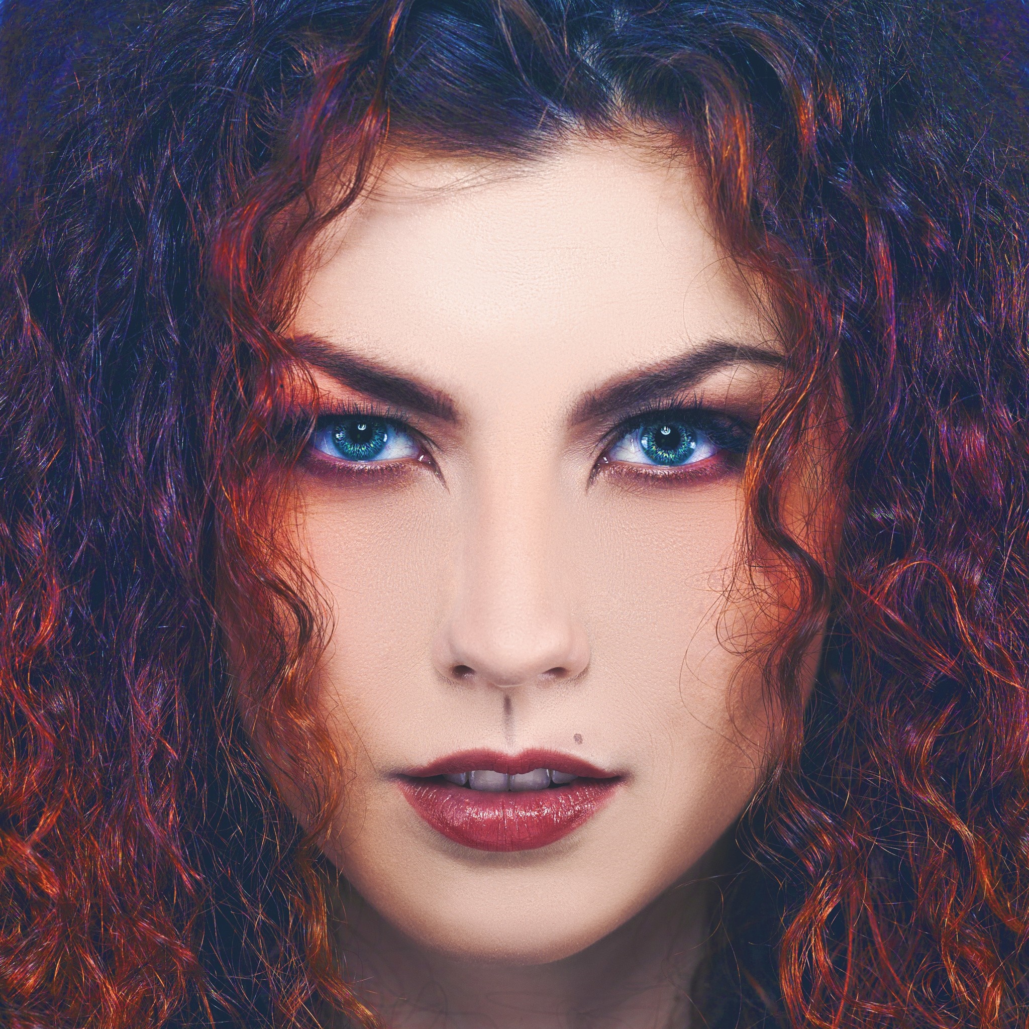 Close up portrait of a woman with curly red and black hair and blue eyes HD Wallpaper