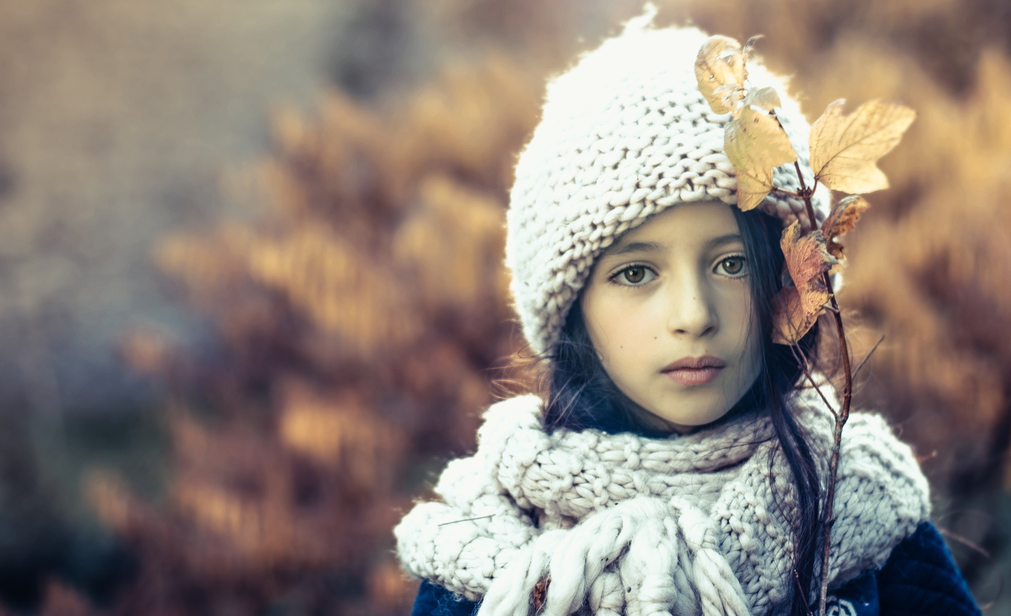 Young girl in winter hat and scarf with autumn leaves HD Wallpaper