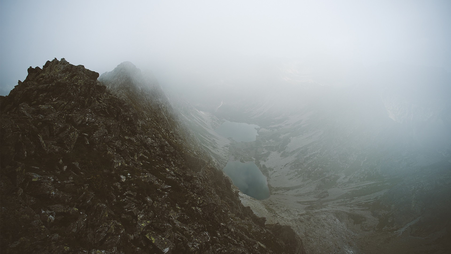 Misty mountain range with lakes and rocky peak HD Wallpaper