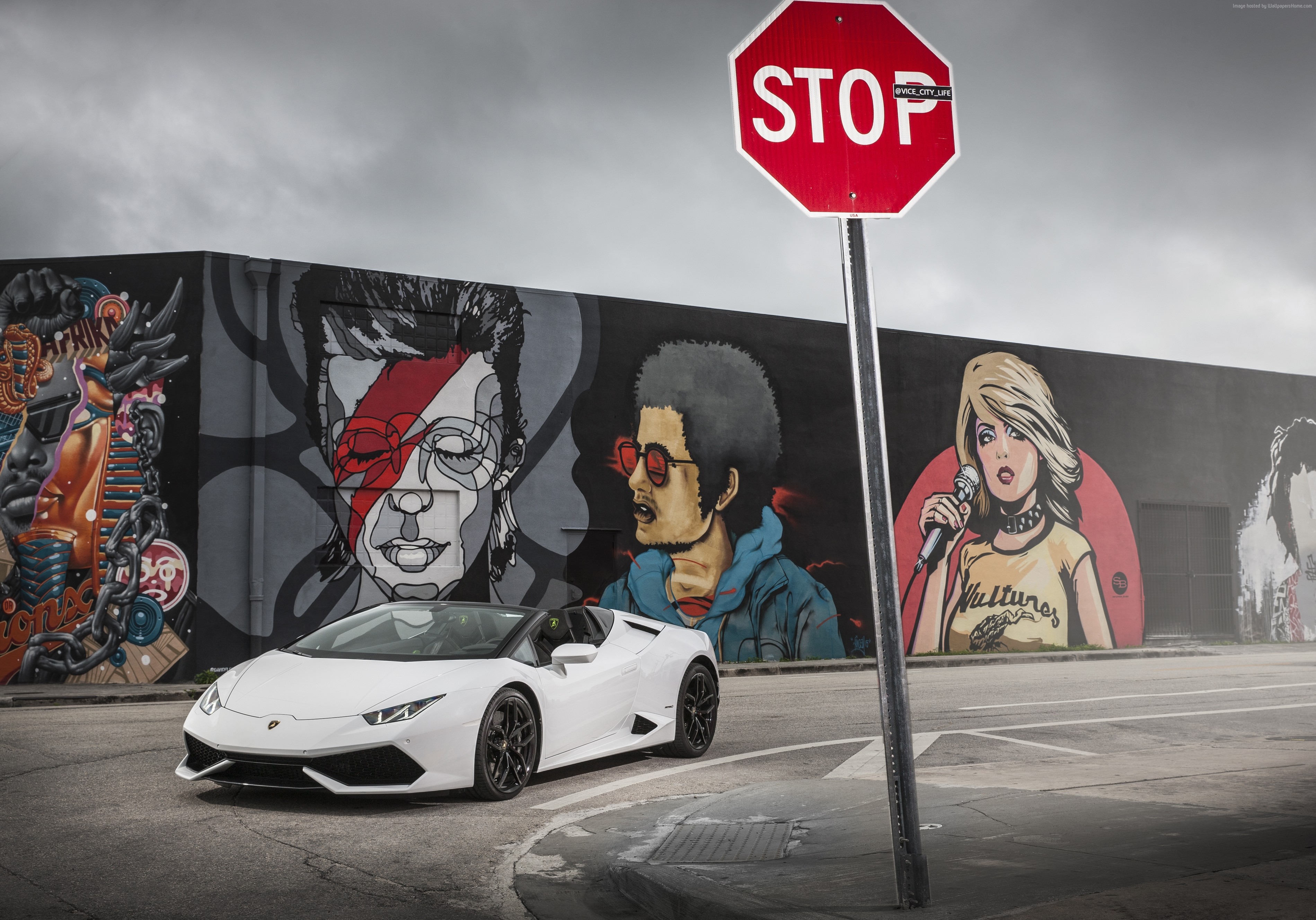 White Lamborghini Huracan Spyder parked near graffiti wall HD Wallpaper
