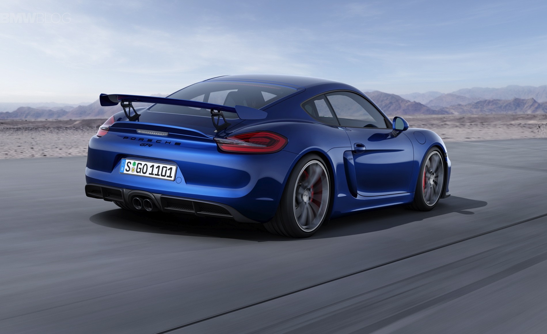 Blue Porsche Cayman GT4 driving on a road HD Wallpaper