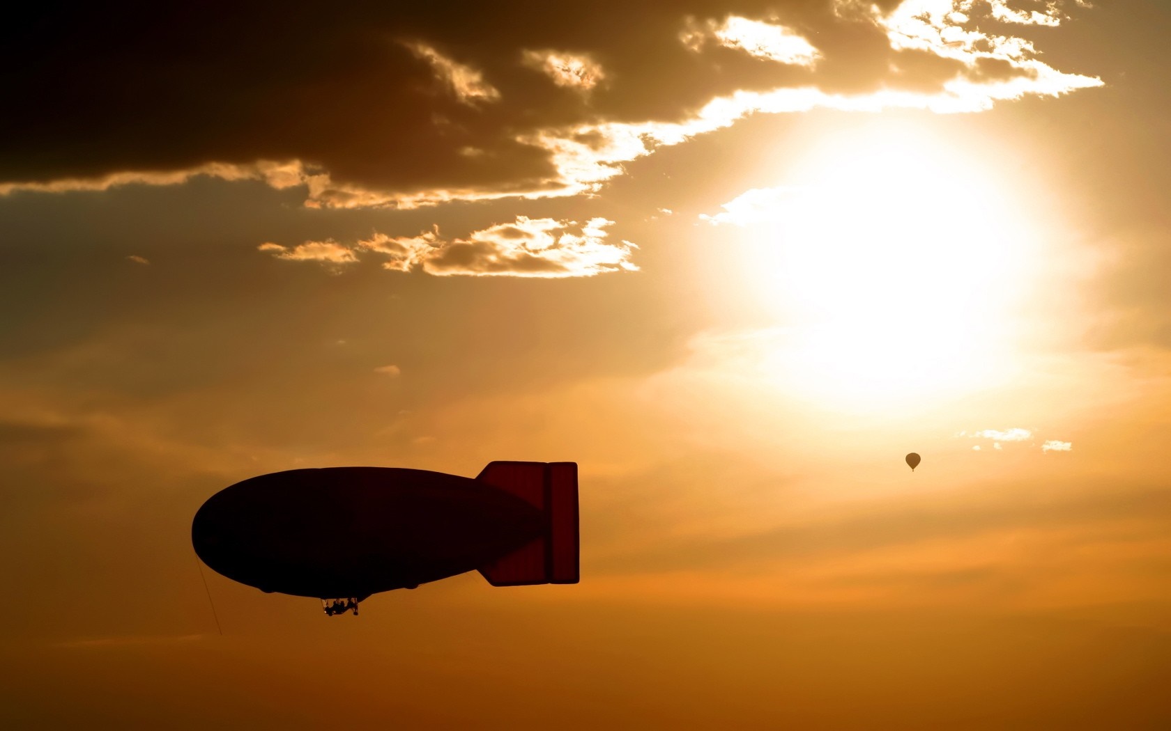 Blimp and hot air balloon at sunset HD Wallpaper