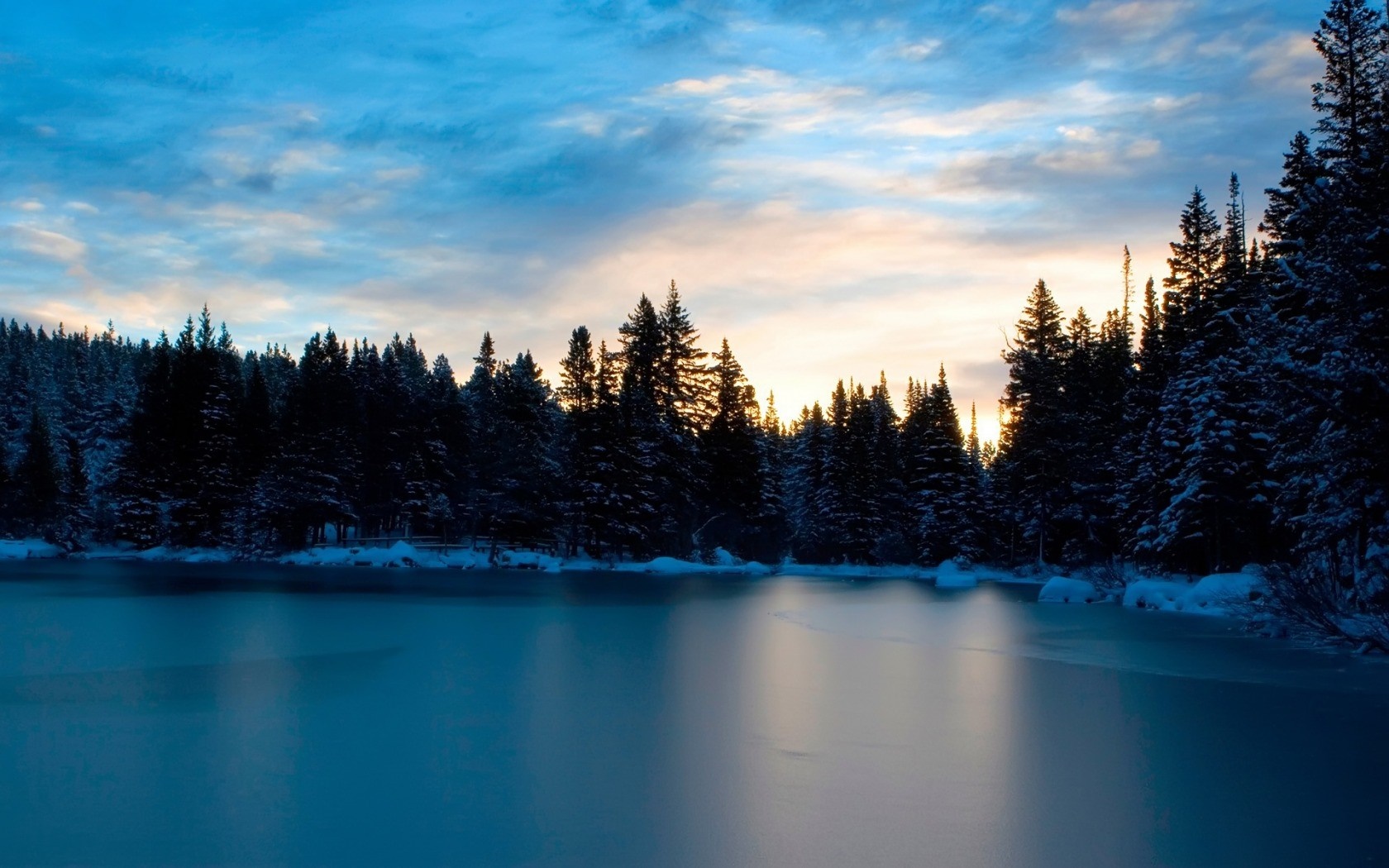 Frozen lake and snow-covered pine forest at sunset HD Wallpaper