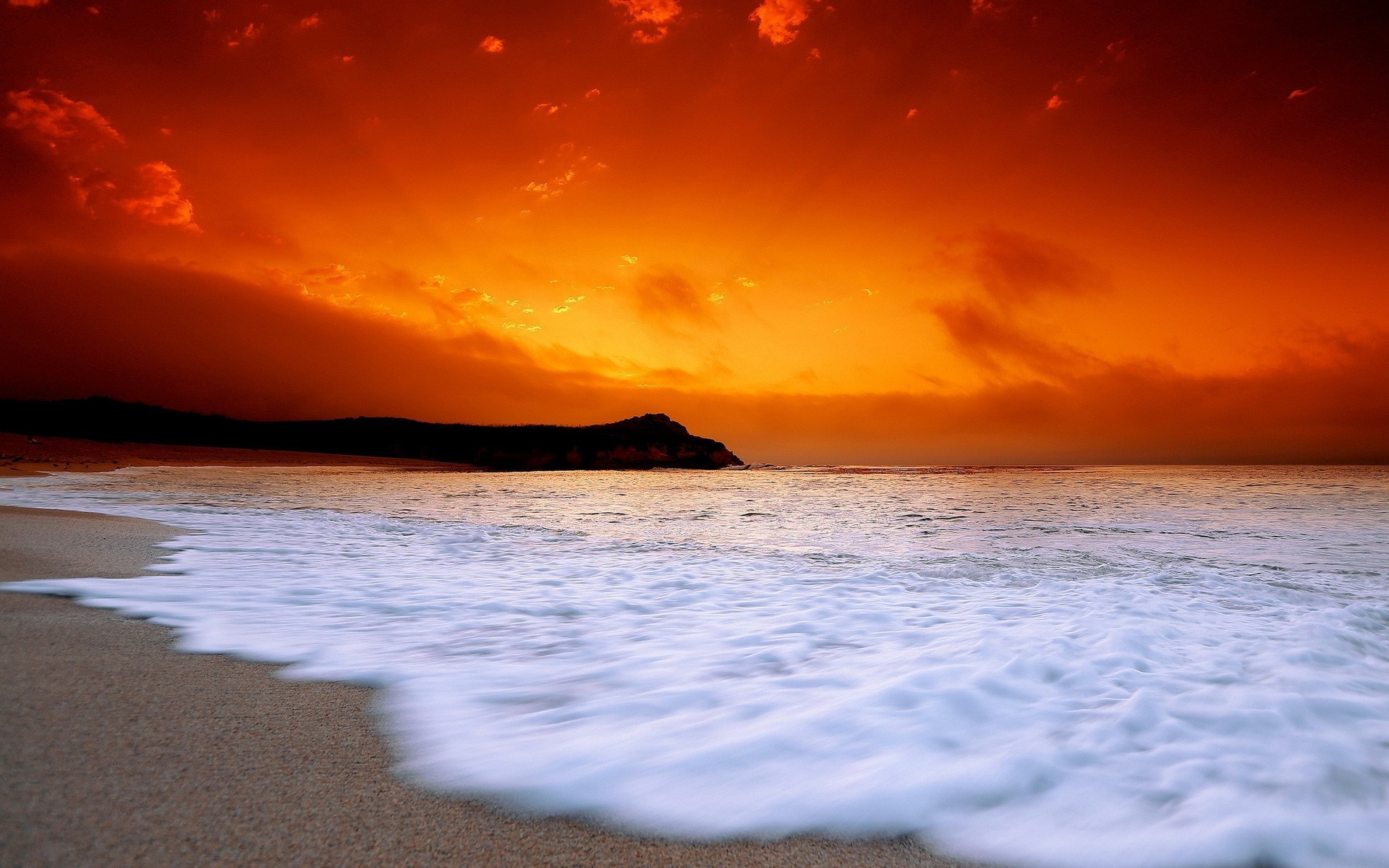 Dramatic sunset over a beach with crashing waves HD Wallpaper