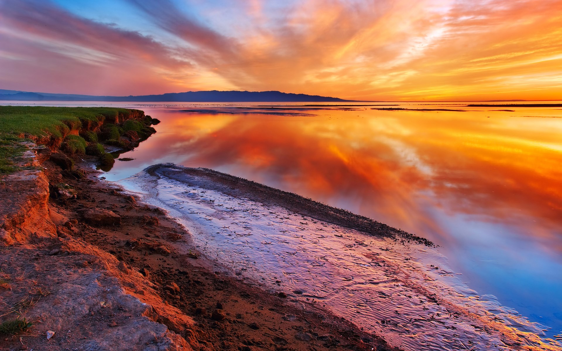 Sunset over a calm body of water with reflections HD Wallpaper