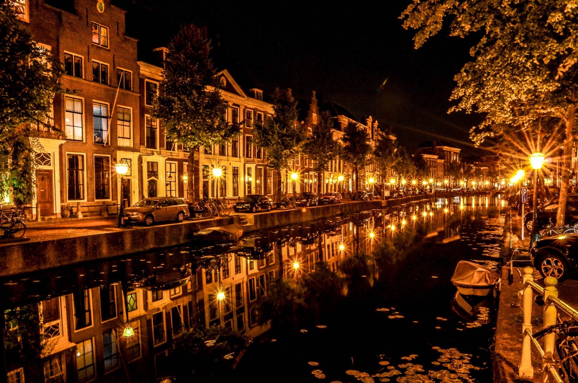 Cityscape at night with canal reflections and streetlights HD Wallpaper