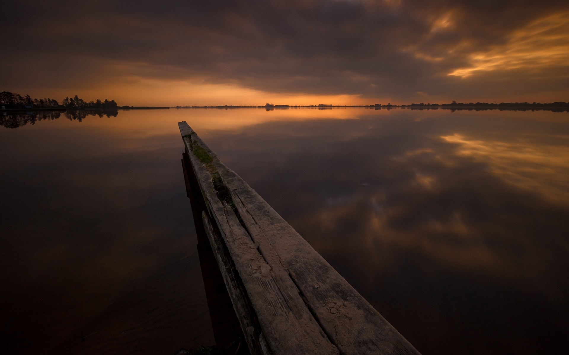 Sunset over a calm lake with a wooden pier HD Wallpaper