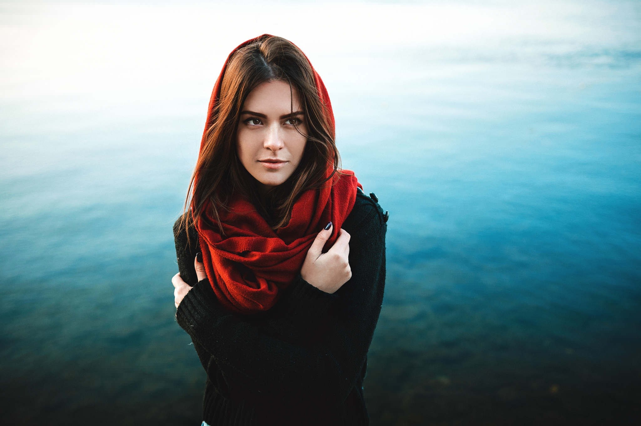 Woman wearing a red scarf and black sweater by the water HD Wallpaper