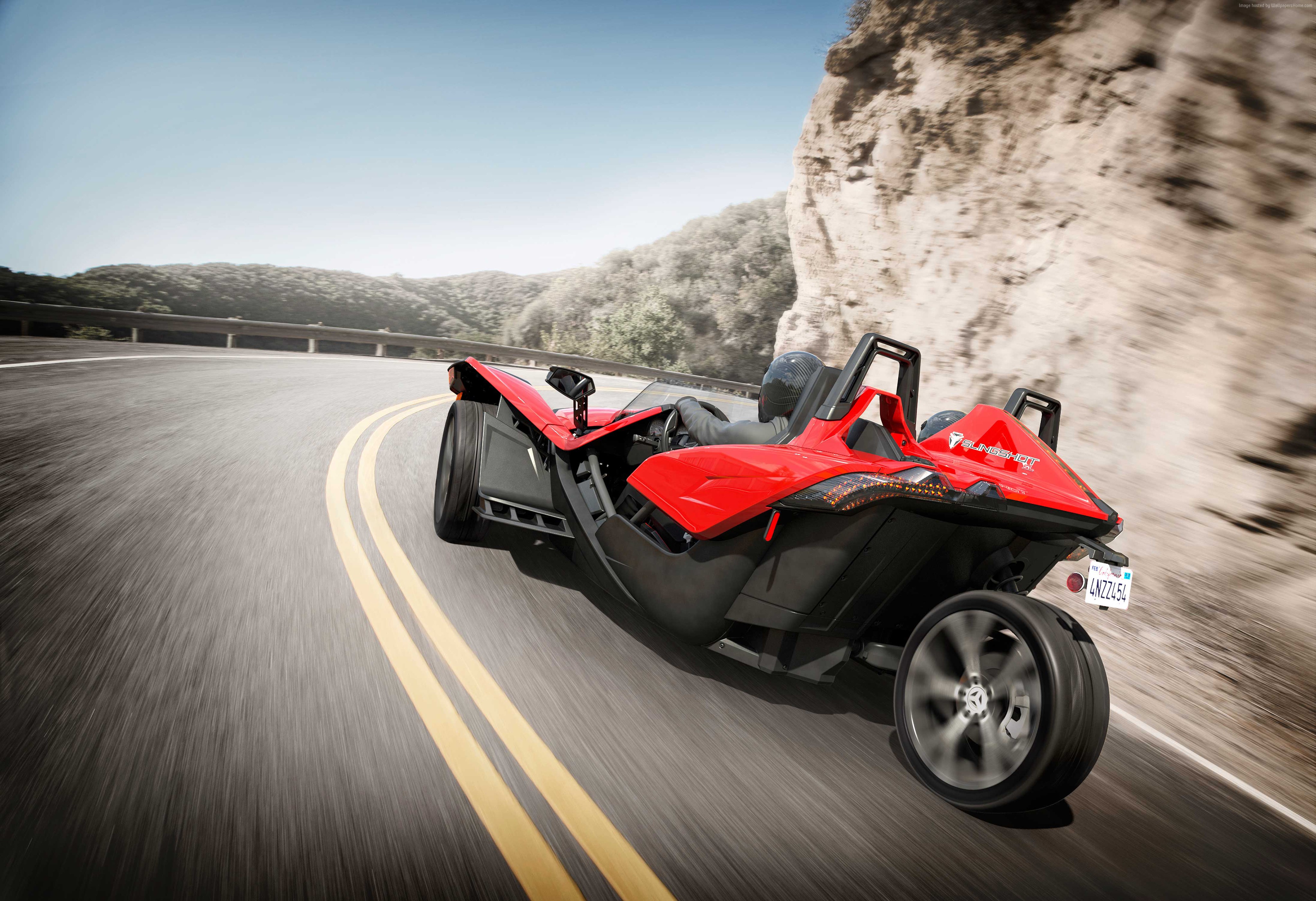 Red Polaris Slingshot driving on a mountain road HD Wallpaper