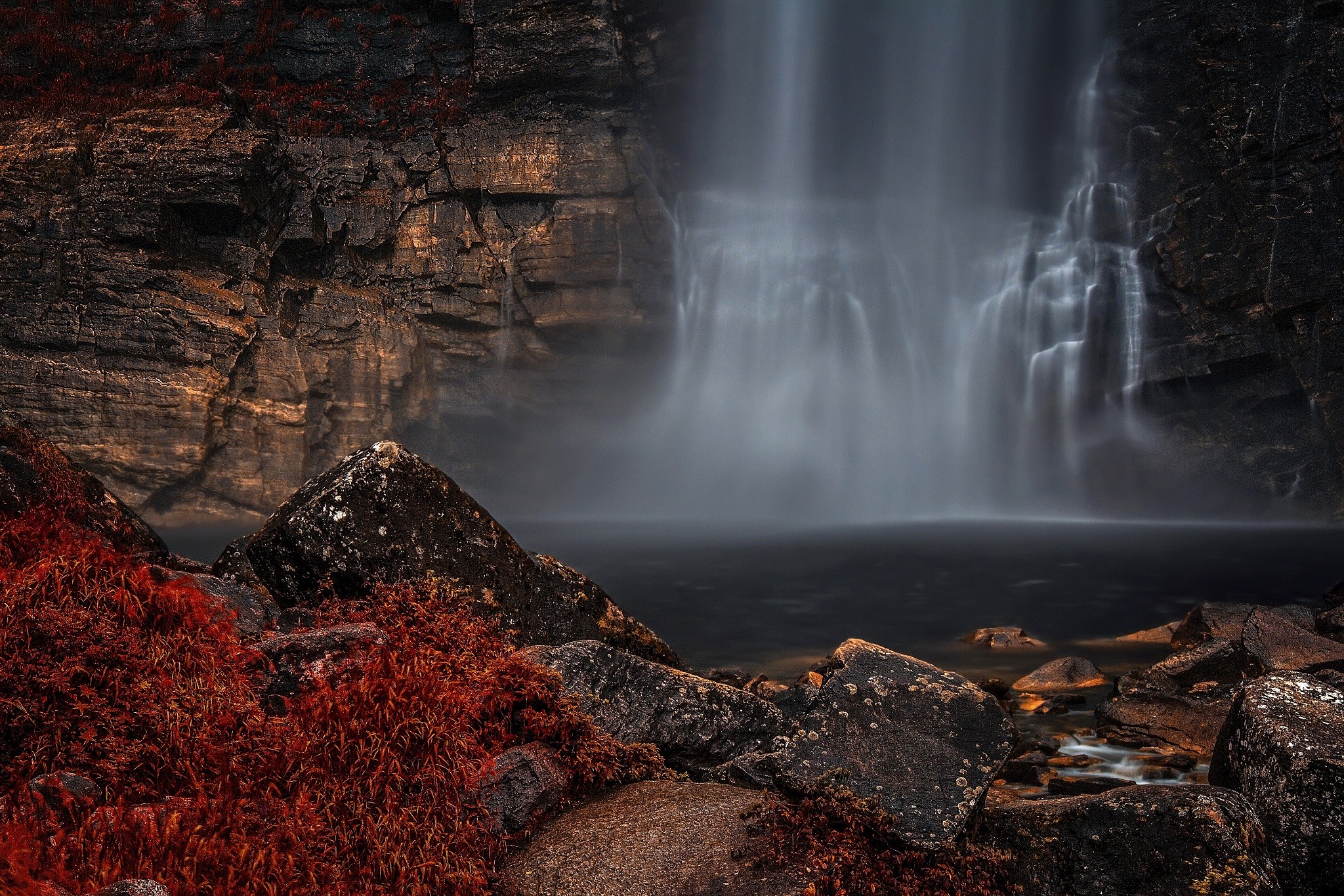 Waterfall cascading over rocky cliff with red foliage HD Wallpaper