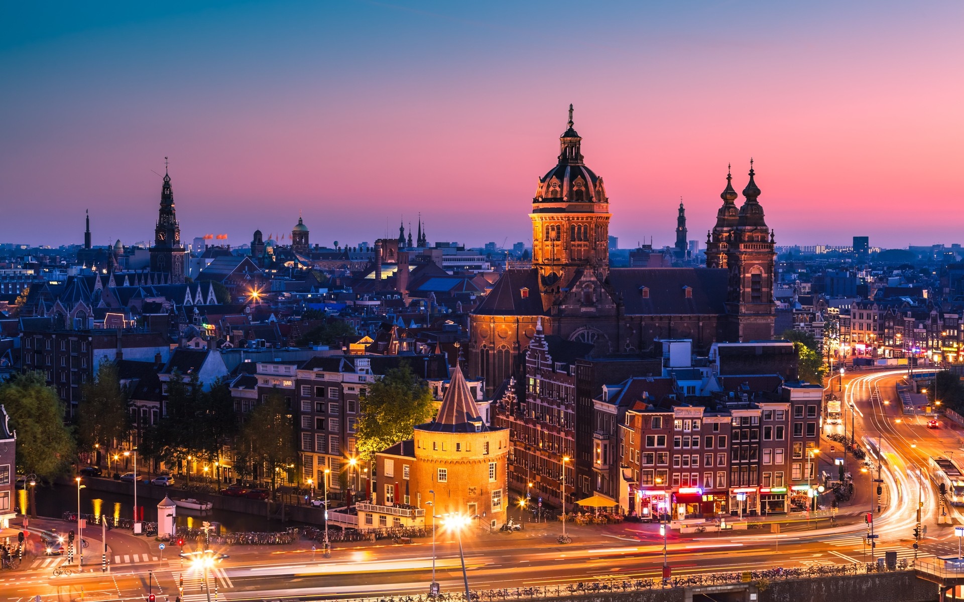 Amsterdam cityscape at dusk with illuminated buildings and canals HD Wallpaper