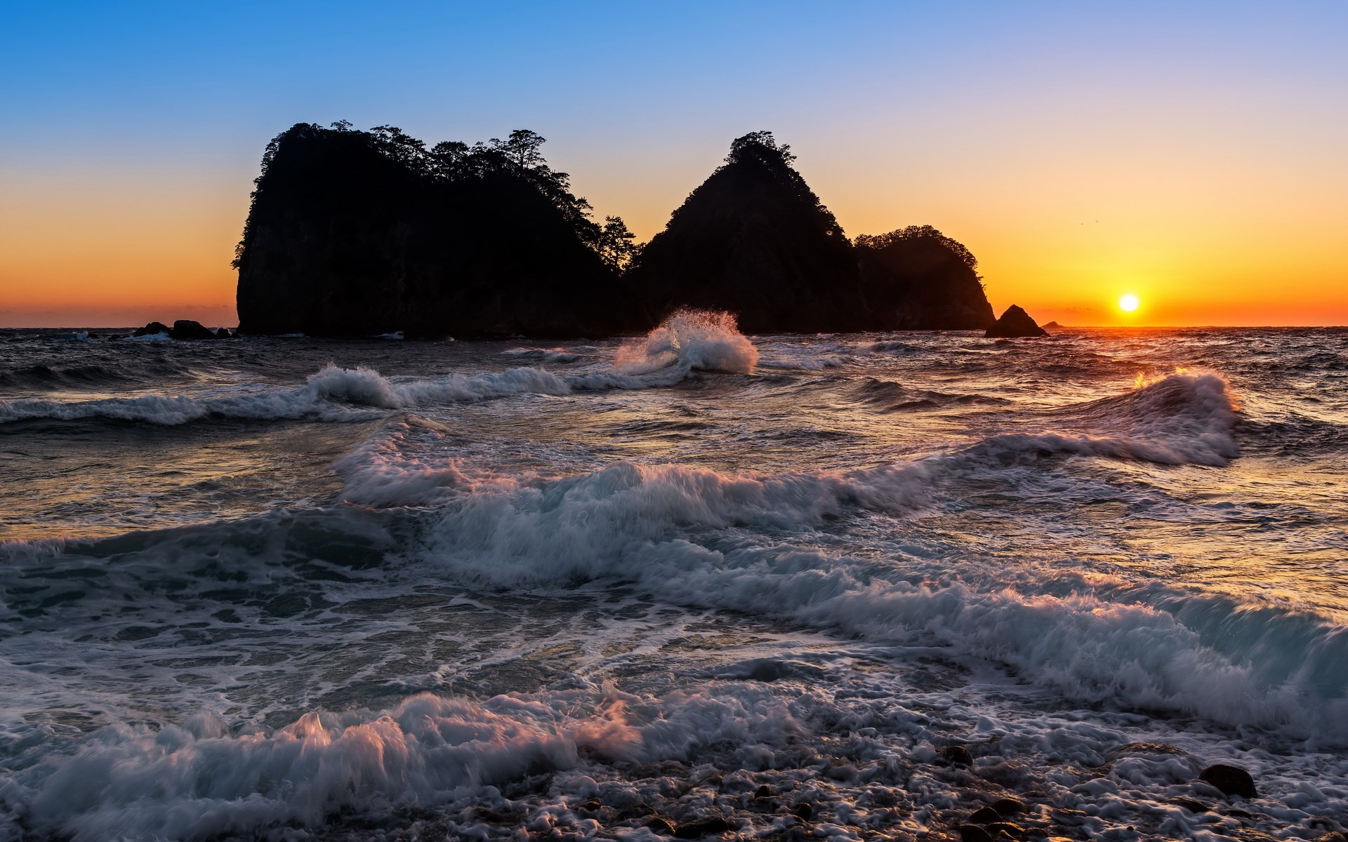 Sunset over the ocean with rocky islands and waves HD Wallpaper