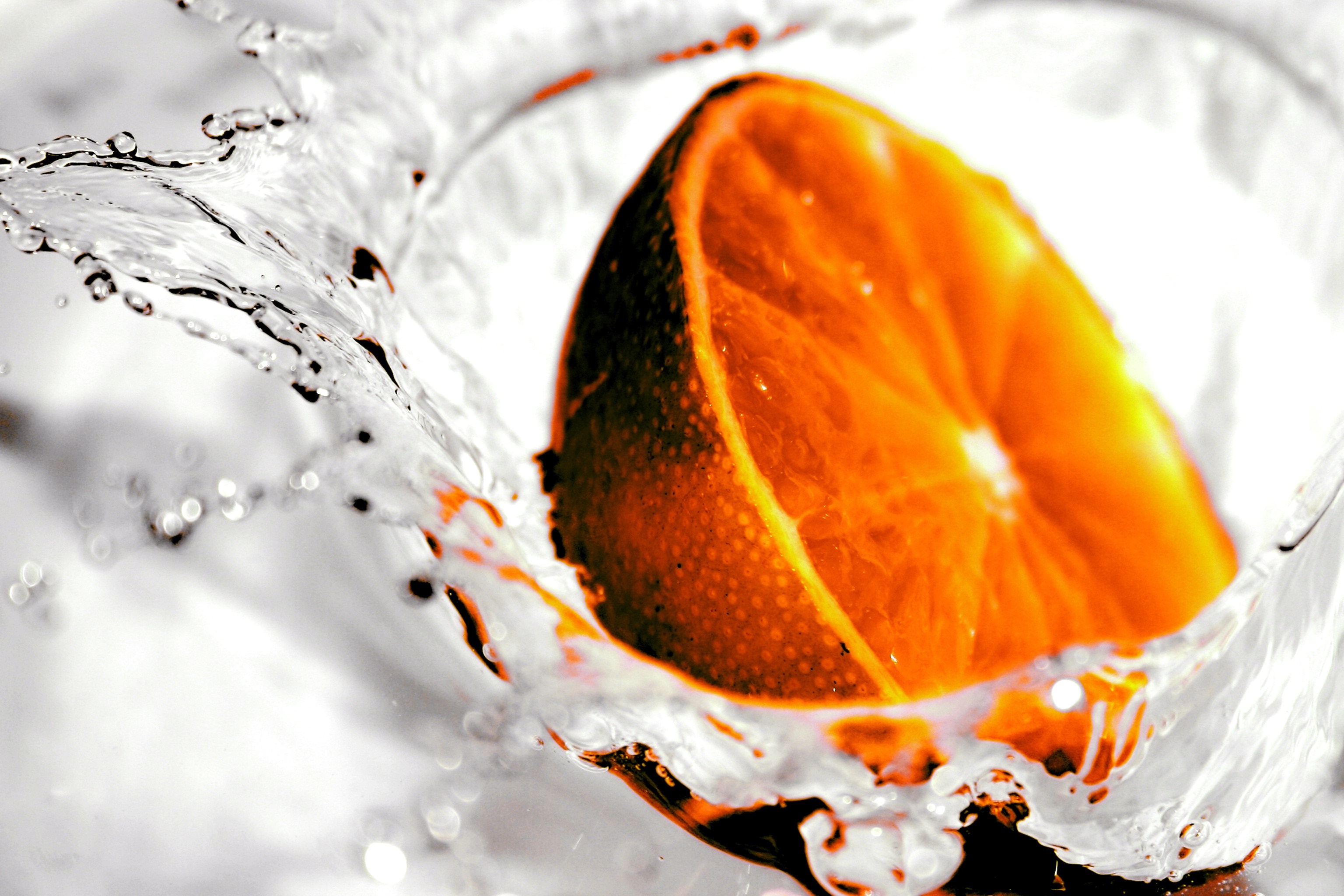Orange slice splashing into water HD Wallpaper