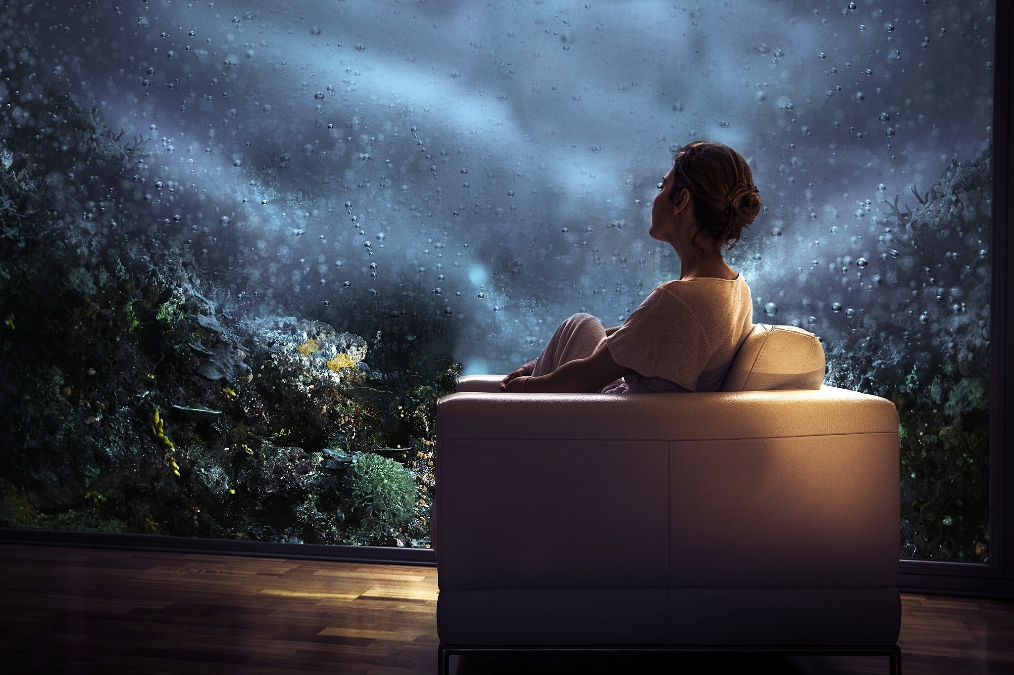 Woman sitting on a couch looking out a window at night HD Wallpaper