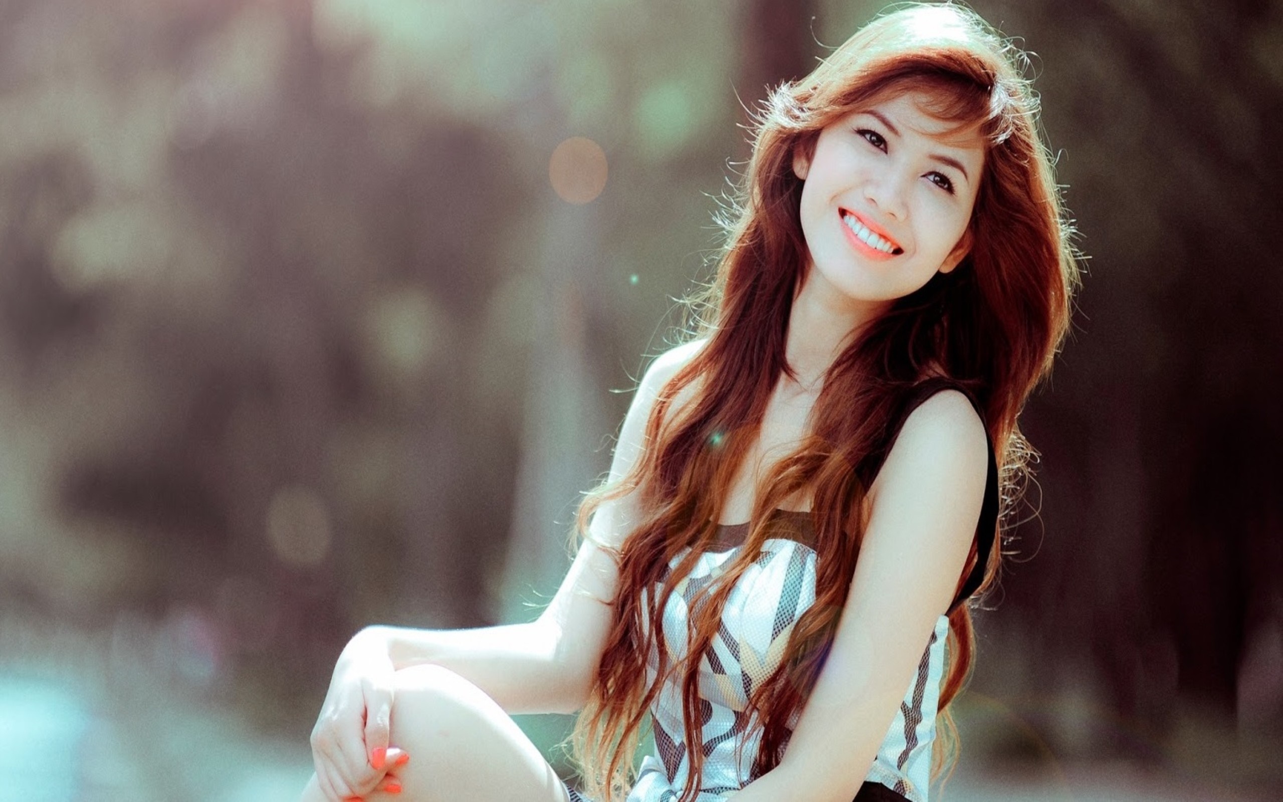 Woman with long brown hair smiling outdoors HD Wallpaper