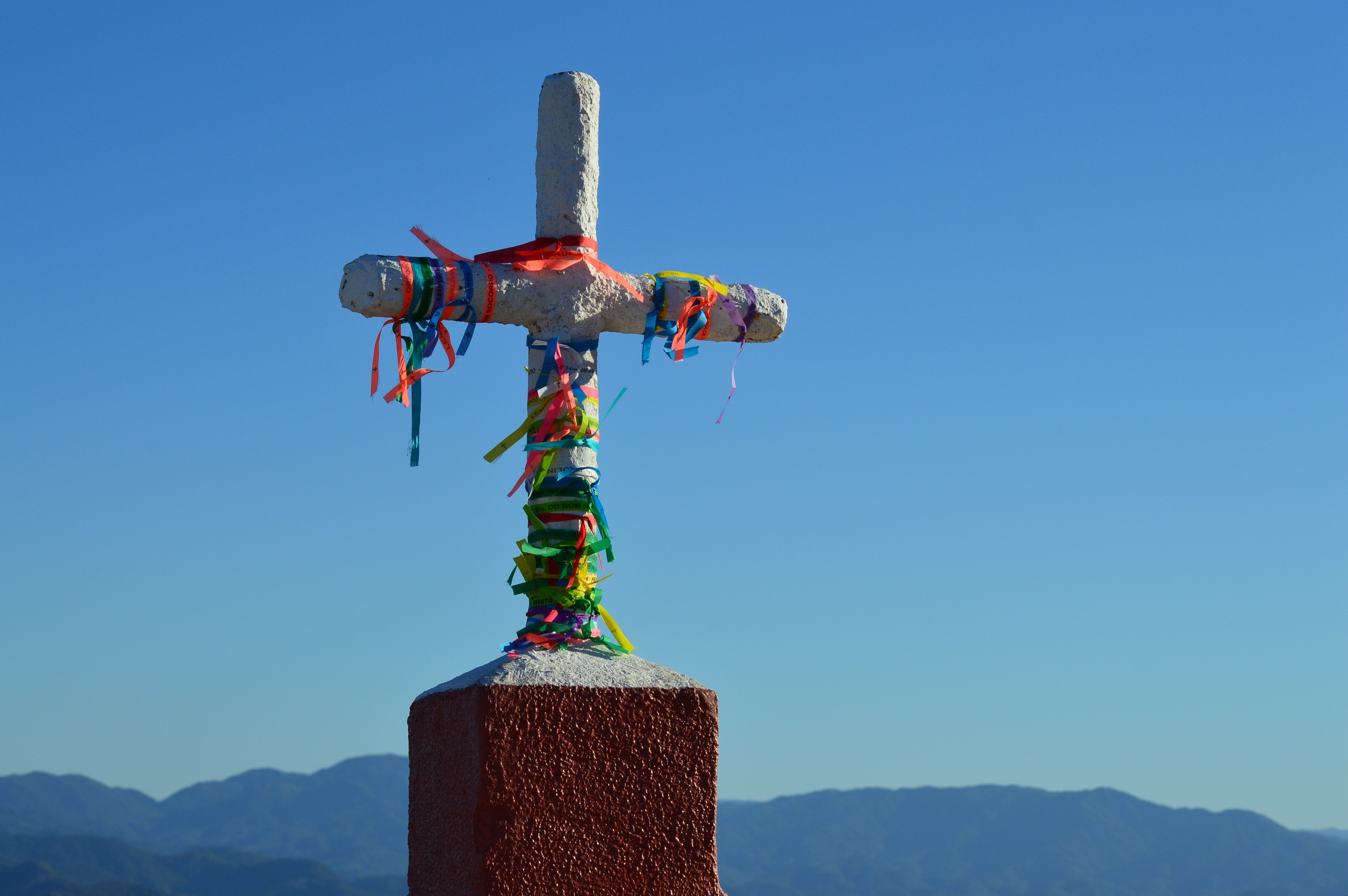 Cross decorated with colorful ribbons against a blue sky HD Wallpaper