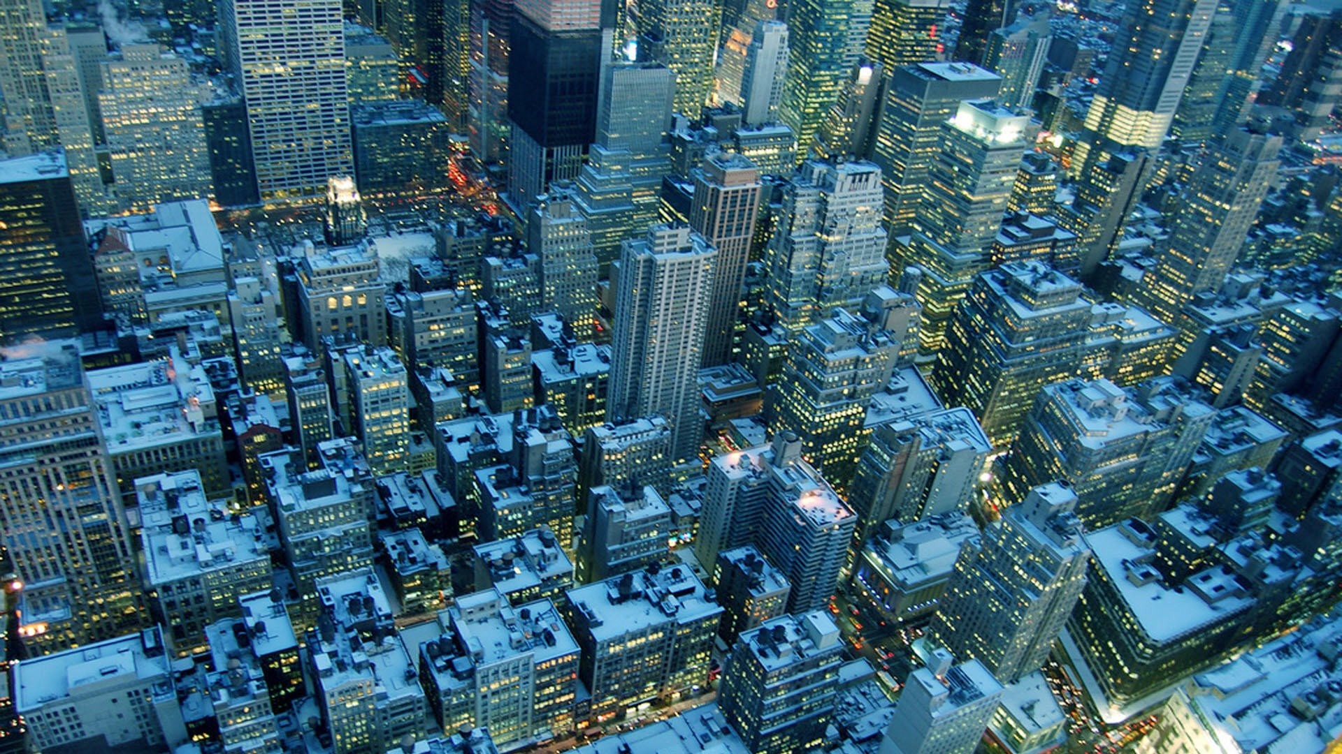 Aerial view of a snowy cityscape at dusk HD Wallpaper