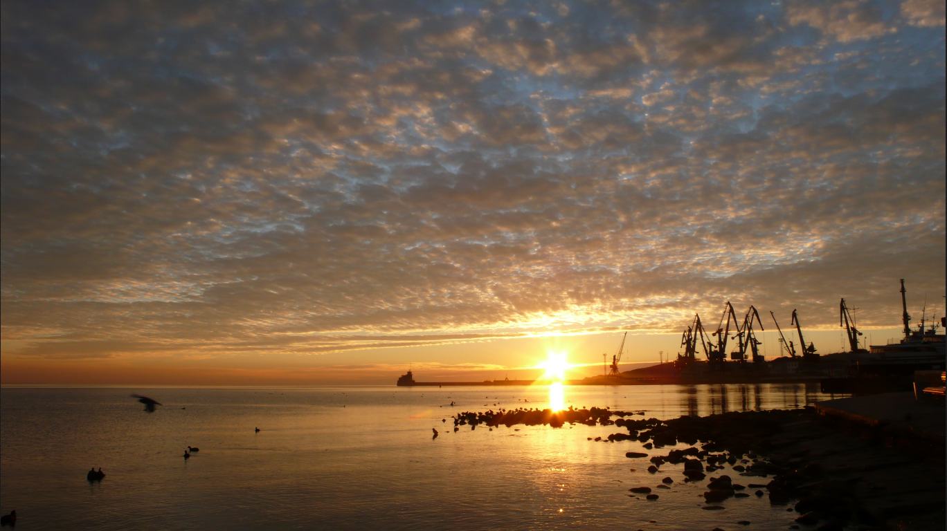 Sunset over the sea with cranes and a ship HD Wallpaper