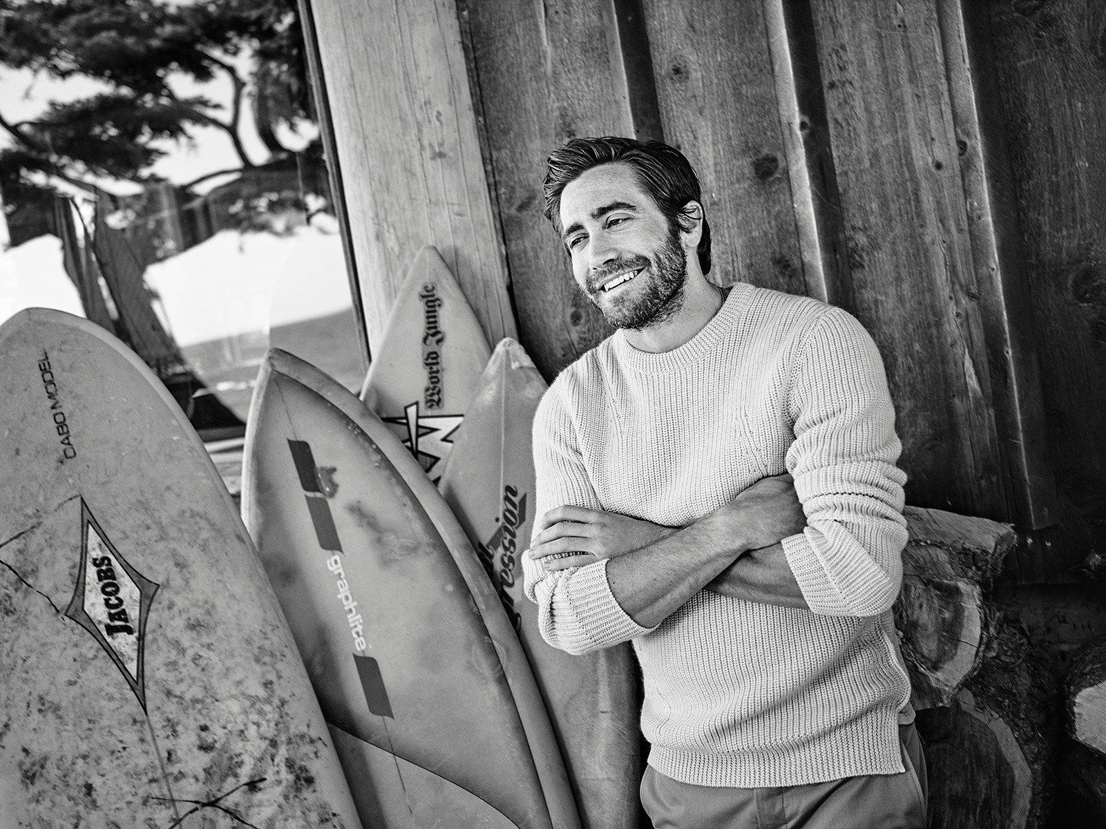 Jake Gyllenhaal leaning against surfboards HD Wallpaper