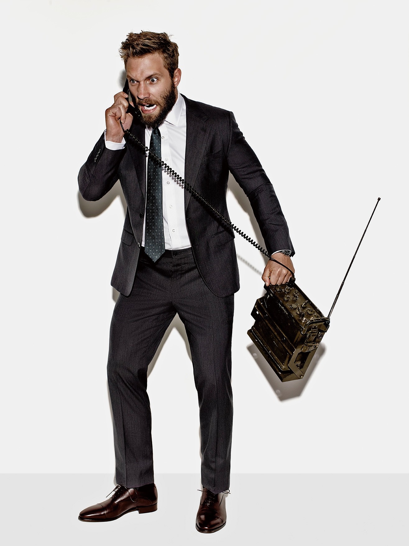 Jai Courtney in a suit holding a vintage radio HD Wallpaper