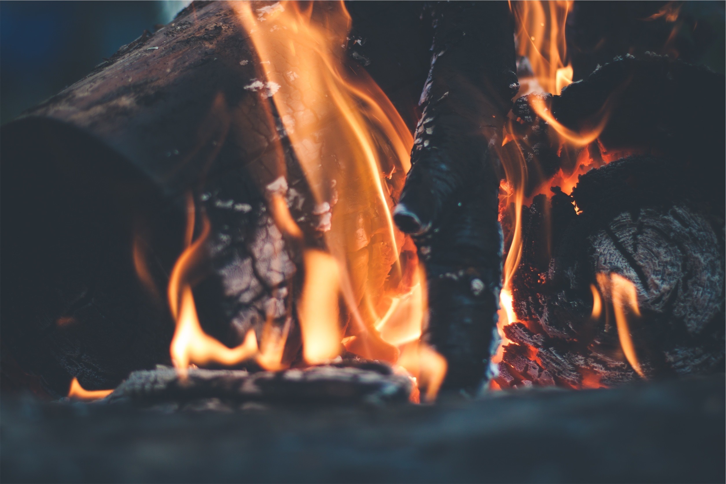 Close-up of burning logs in a fireplace with flames HD Wallpaper