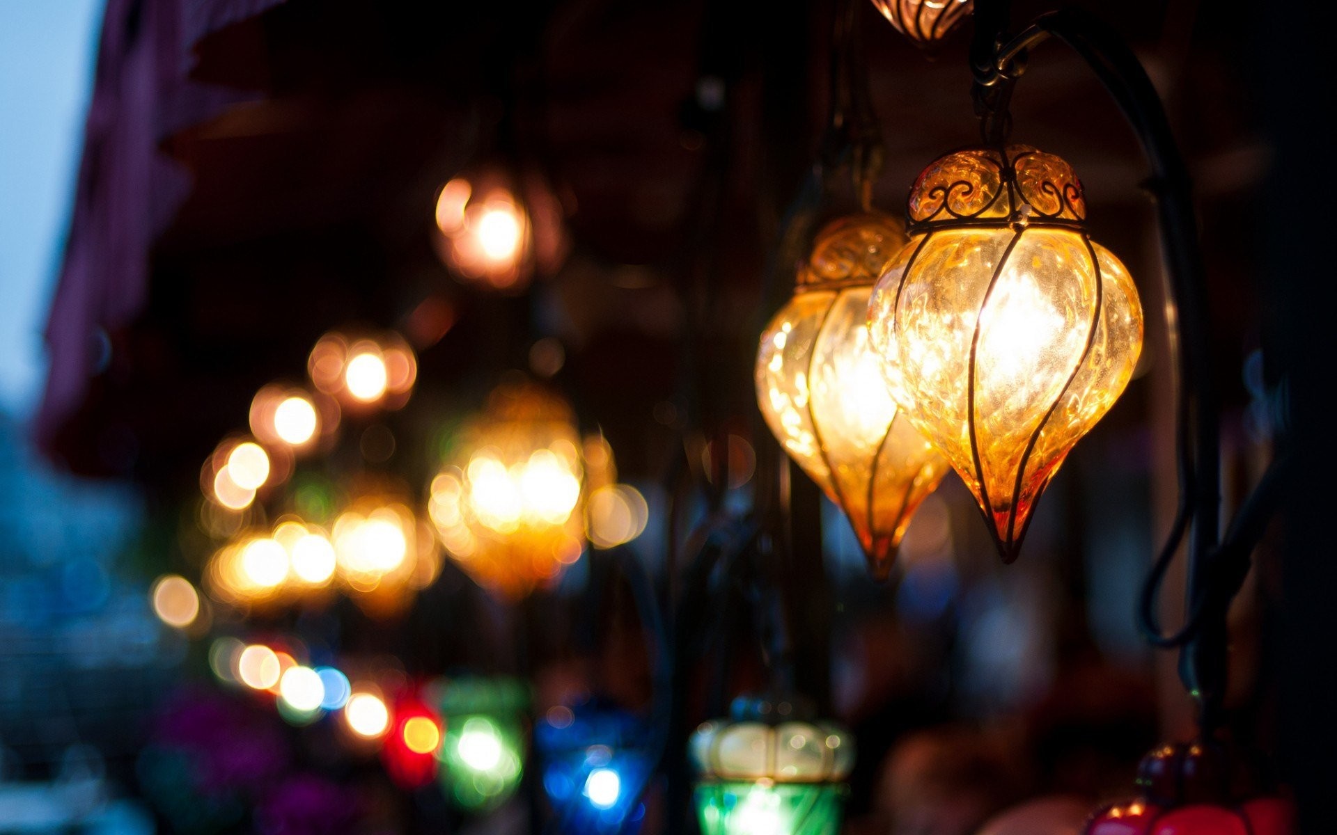 Close-up of illuminated glass lanterns with bokeh lights HD Wallpaper