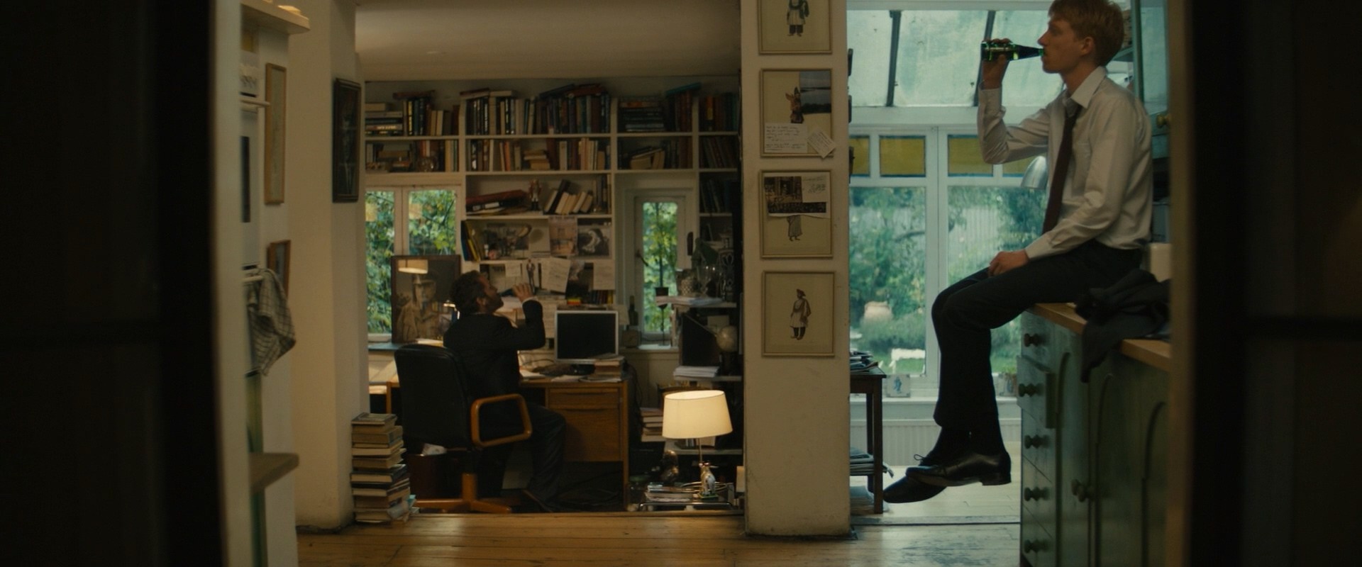 Two men in a room with bookshelves and a window HD Wallpaper