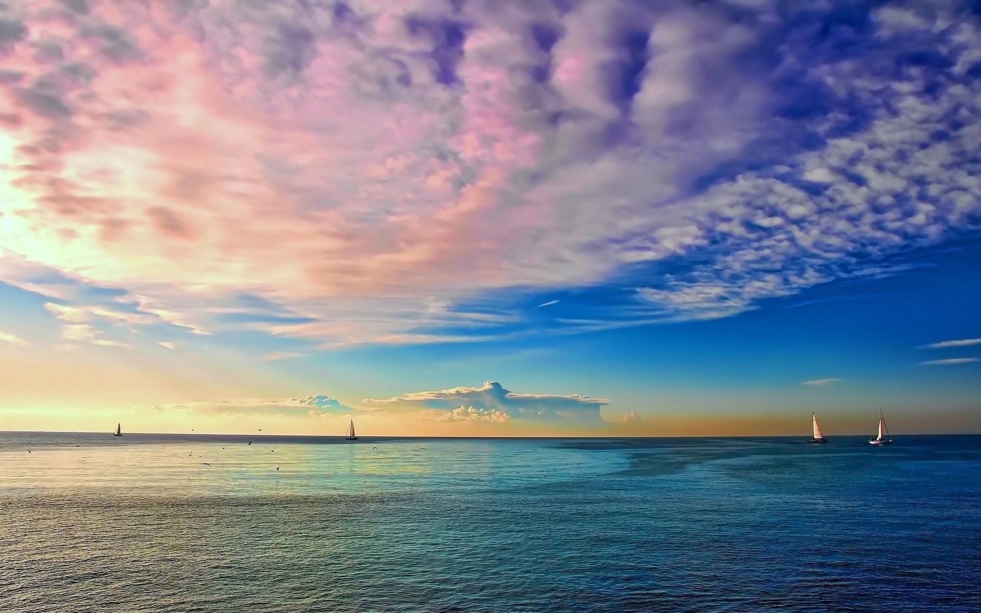 Sailboats on the ocean at sunset with colorful clouds HD Wallpaper