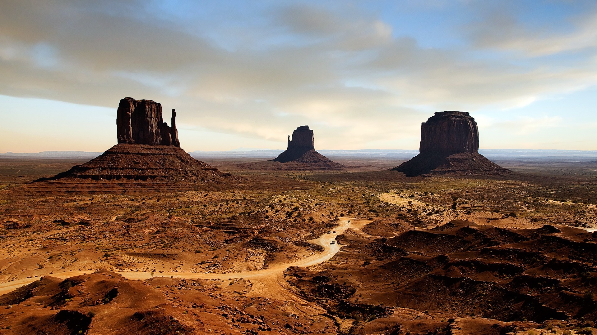 Monument Valley buttes at sunset with dirt road HD Wallpaper