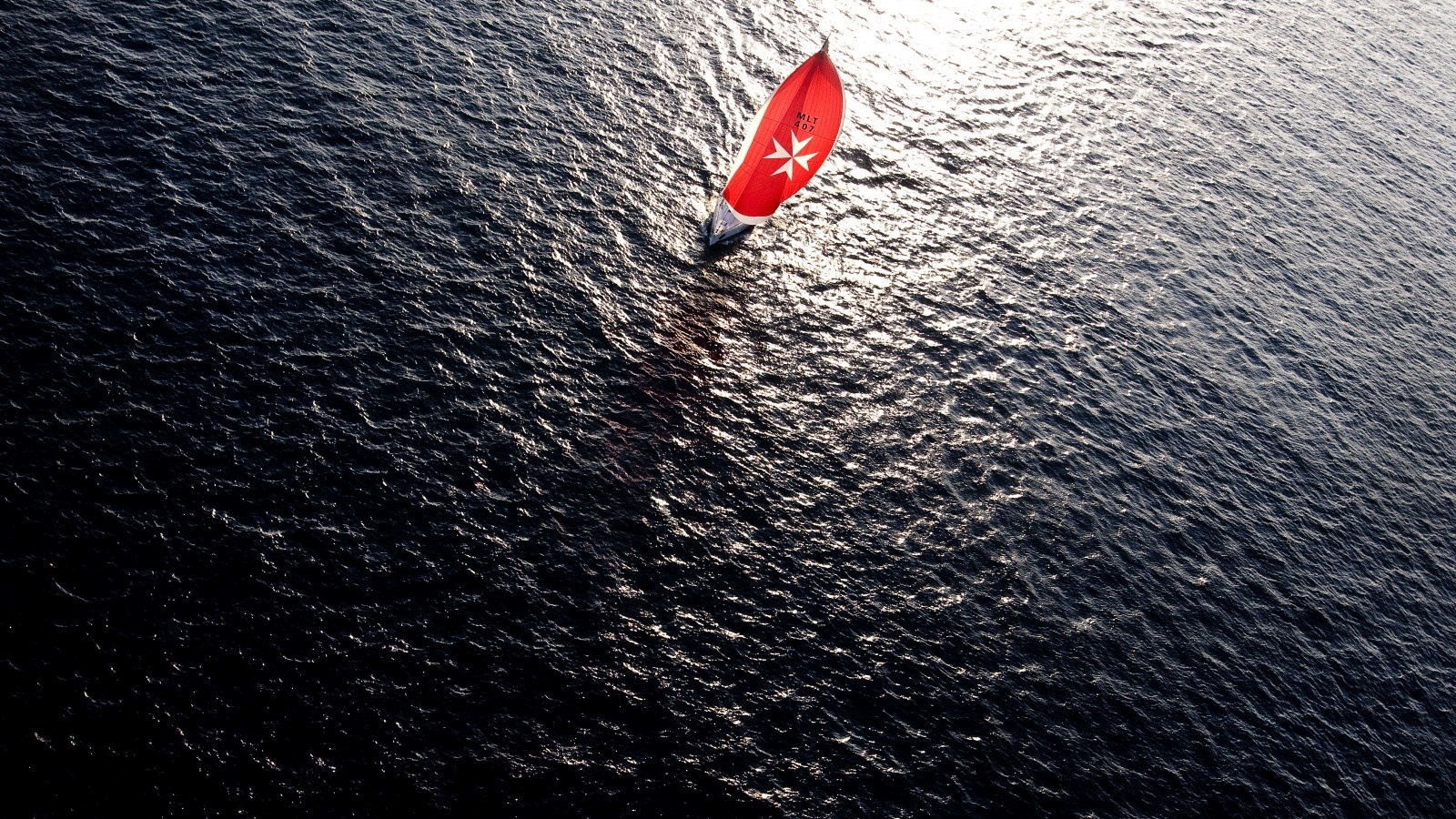 Sailboat with red sail on dark water HD Wallpaper