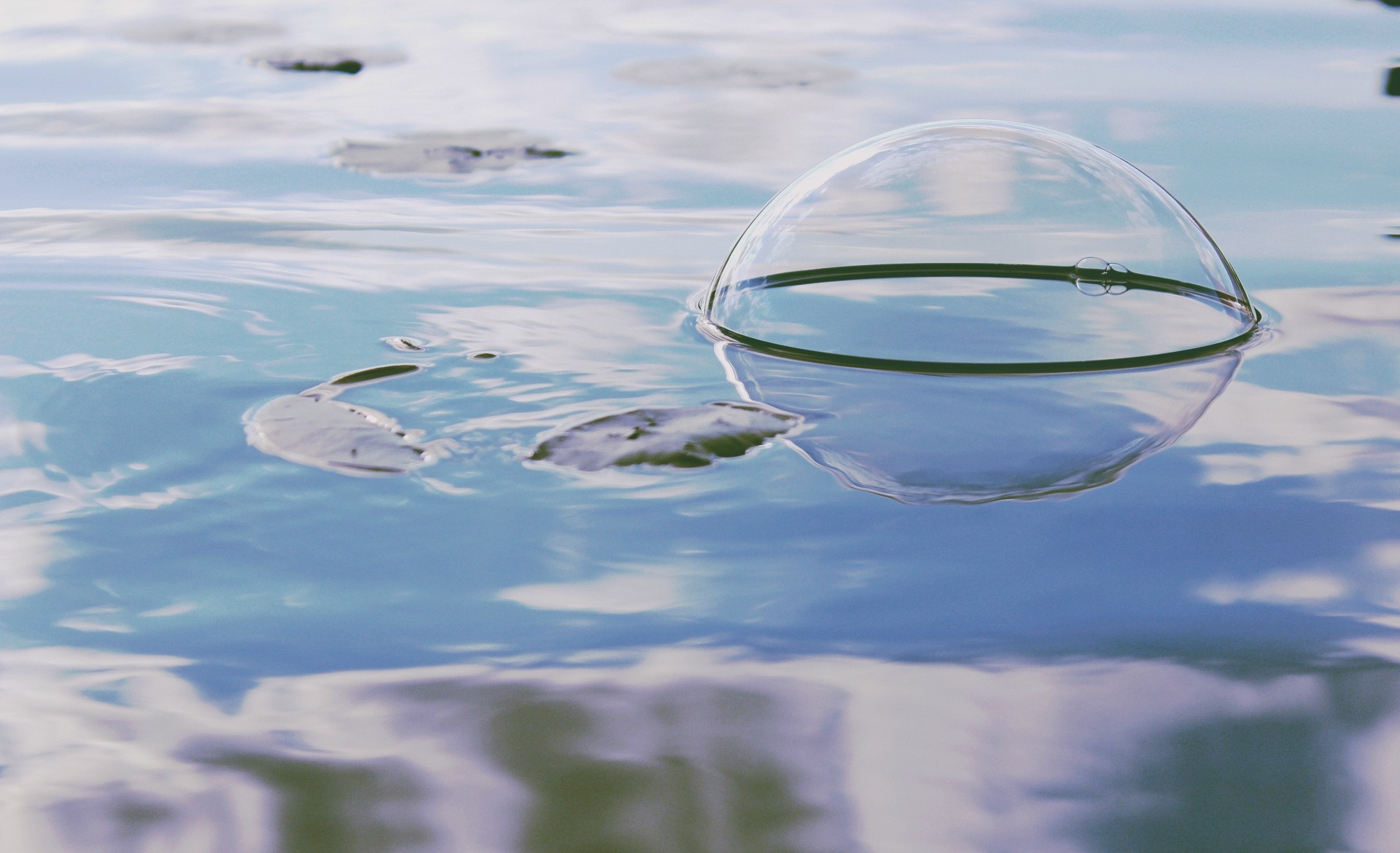 Bubble floating on water with reflections HD Wallpaper