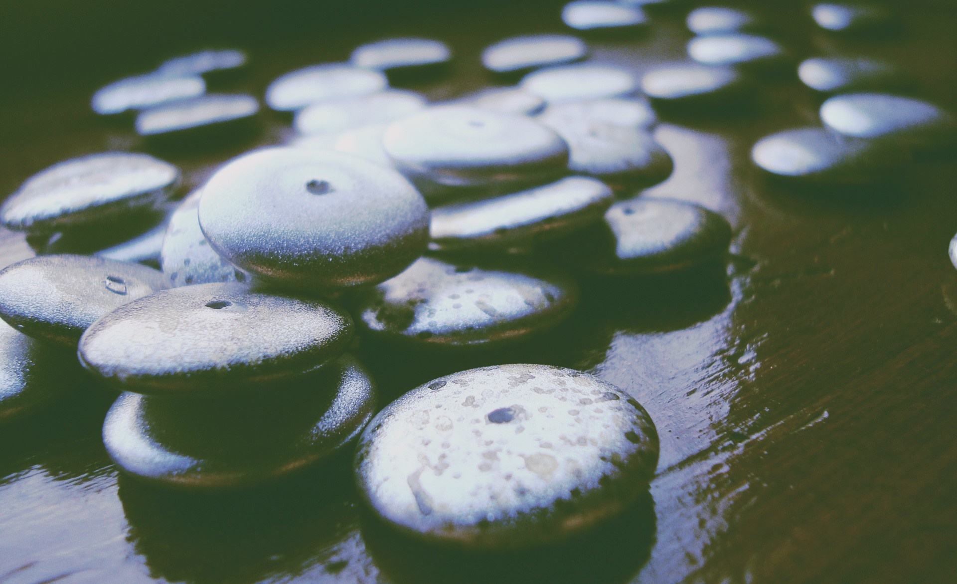 Close up of smooth, round stones with holes HD Wallpaper
