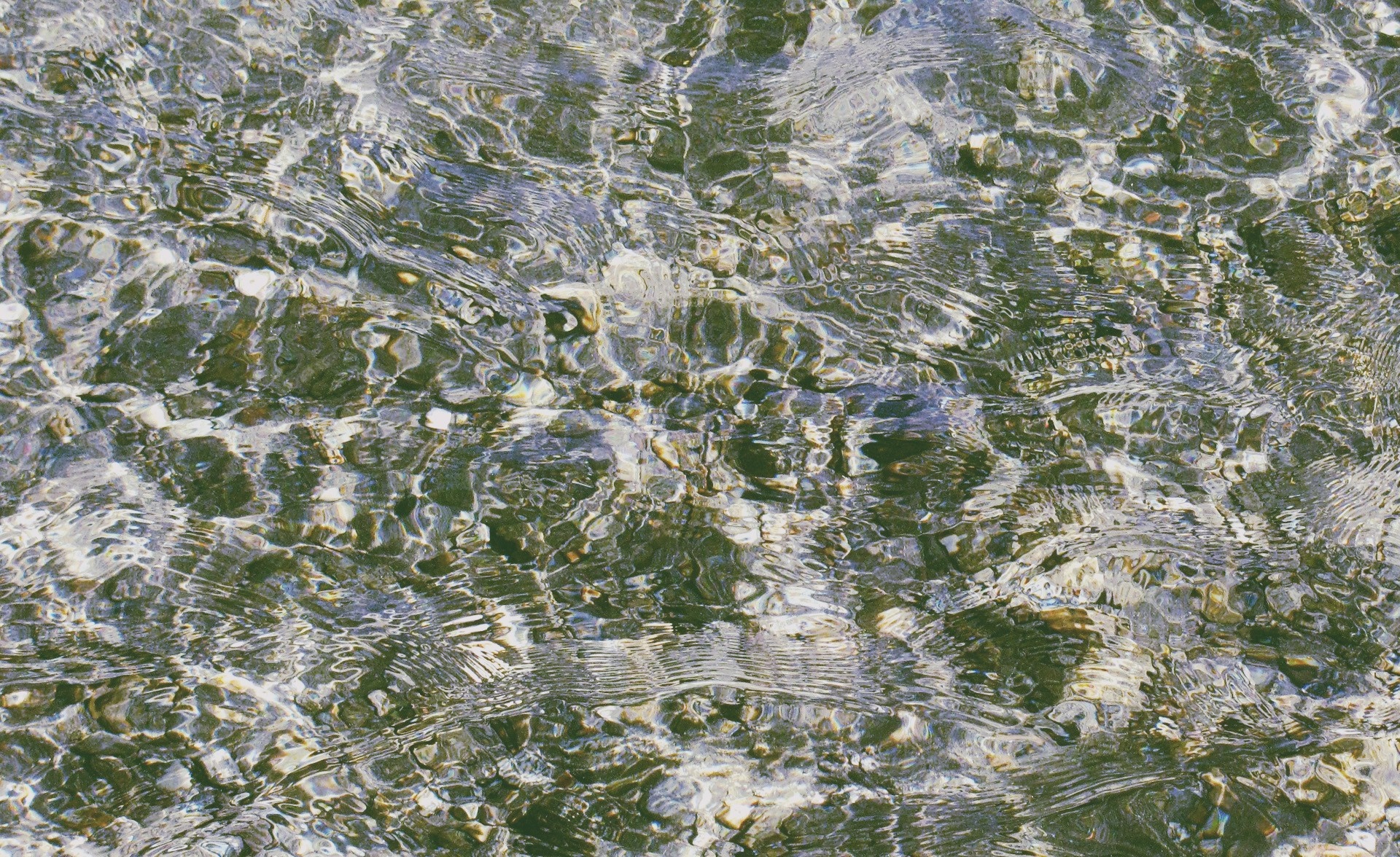 Water surface with pebbles and light reflections HD Wallpaper