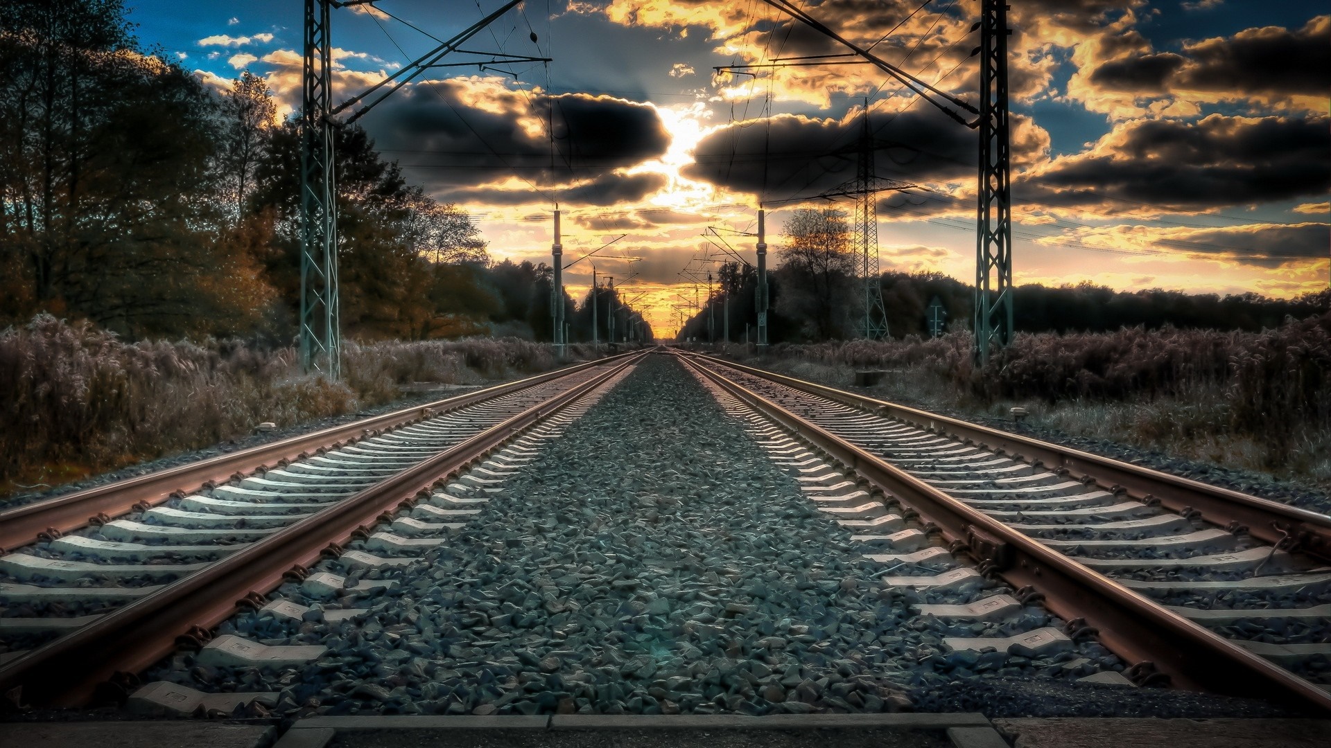 Train tracks at sunset with overhead power lines HD Wallpaper