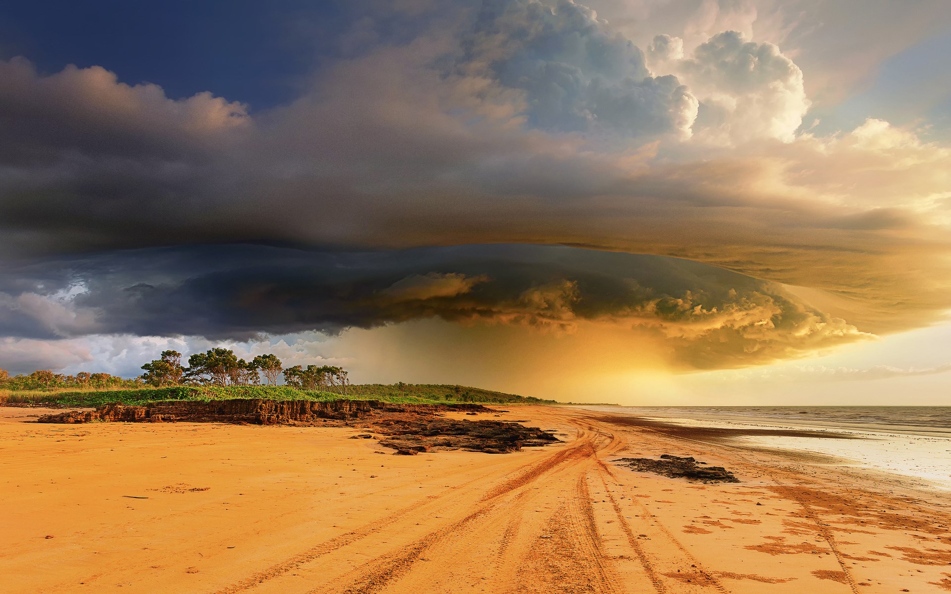 Storm clouds over a sandy beach and ocean HD Wallpaper