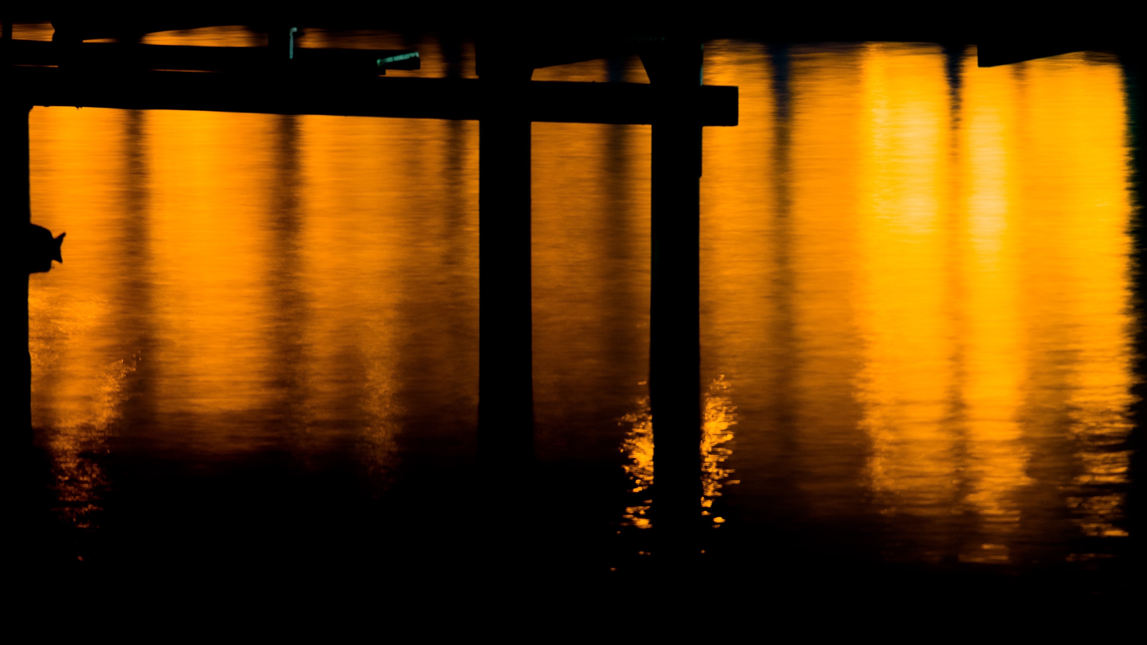 Orange light reflecting on water at night HD Wallpaper