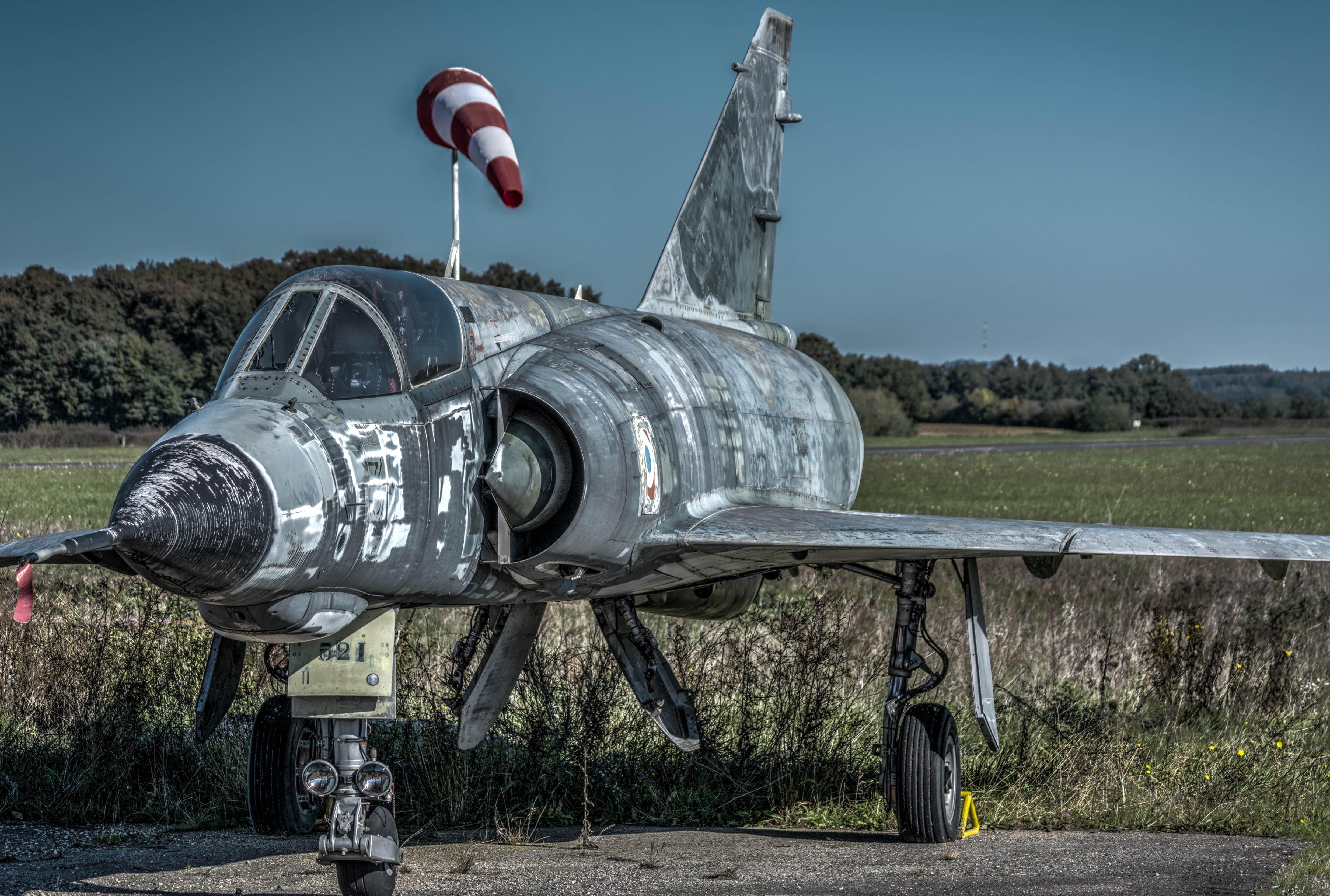 Abandoned Dassault Mirage IIIE fighter jet on a grassy field HD Wallpaper