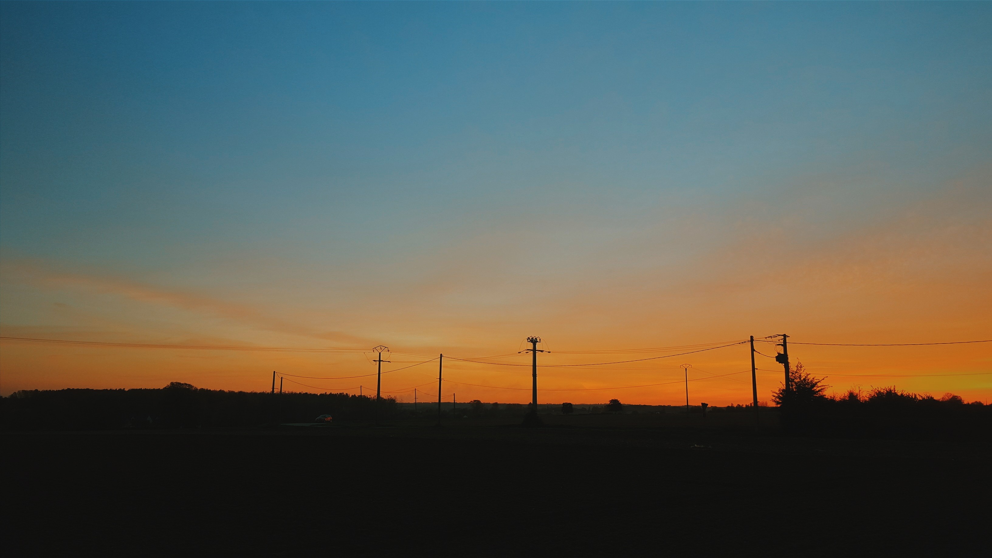 Silhouette of telephone poles against a sunset sky HD Wallpaper