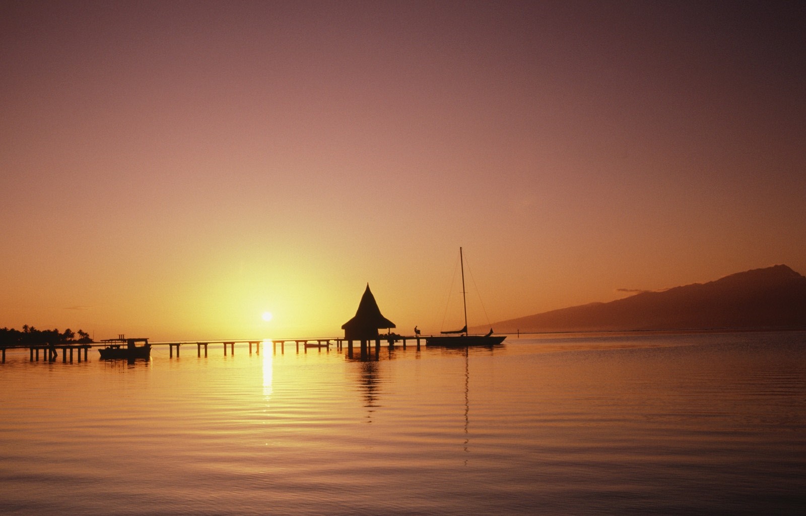 Sunset over the ocean with a pier and sailboat HD Wallpaper