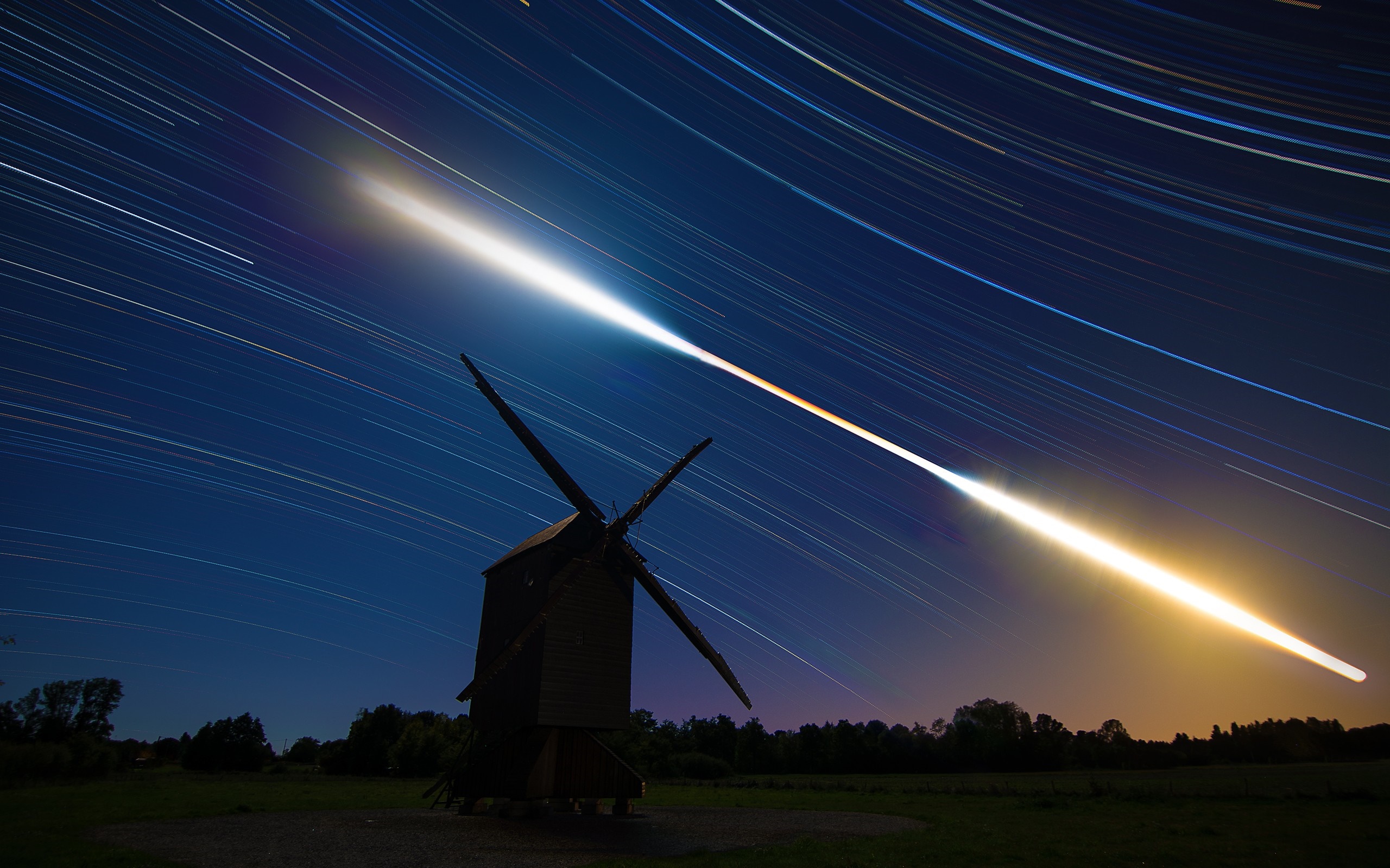 Windmill with star trails and meteor shower at night HD Wallpaper