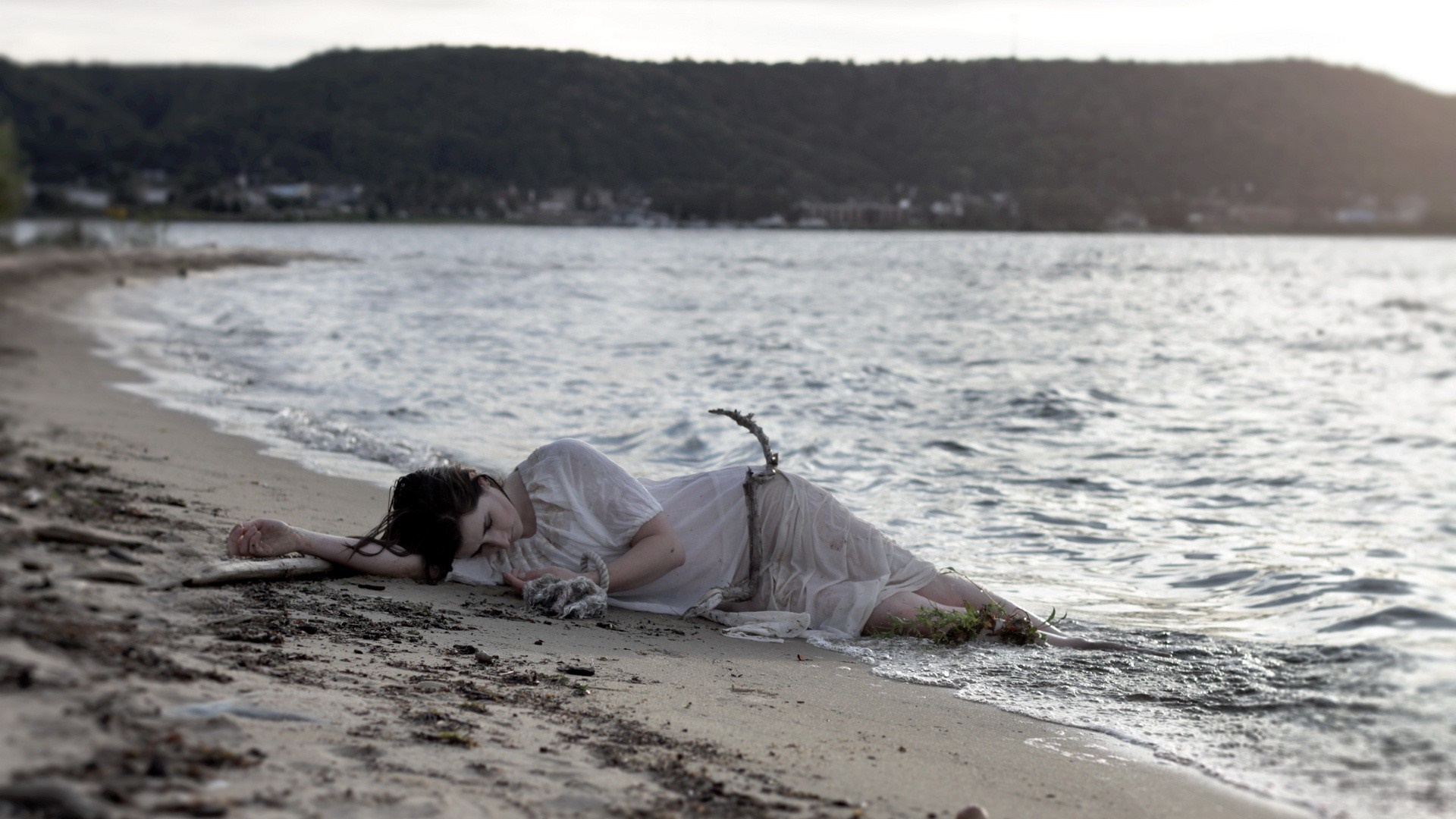 Woman in white dress lying on a sandy beach by the sea HD Wallpaper