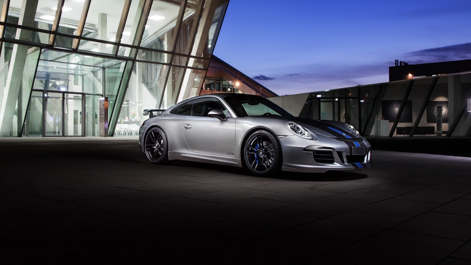Silver Porsche 911 GTS with blue stripes parked outside modern building HD Wallpaper