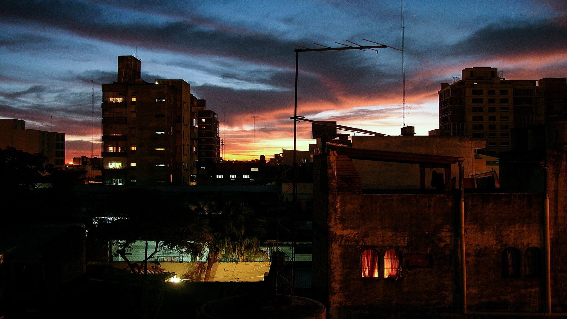 Cityscape at dusk with colorful sky and illuminated buildings HD Wallpaper