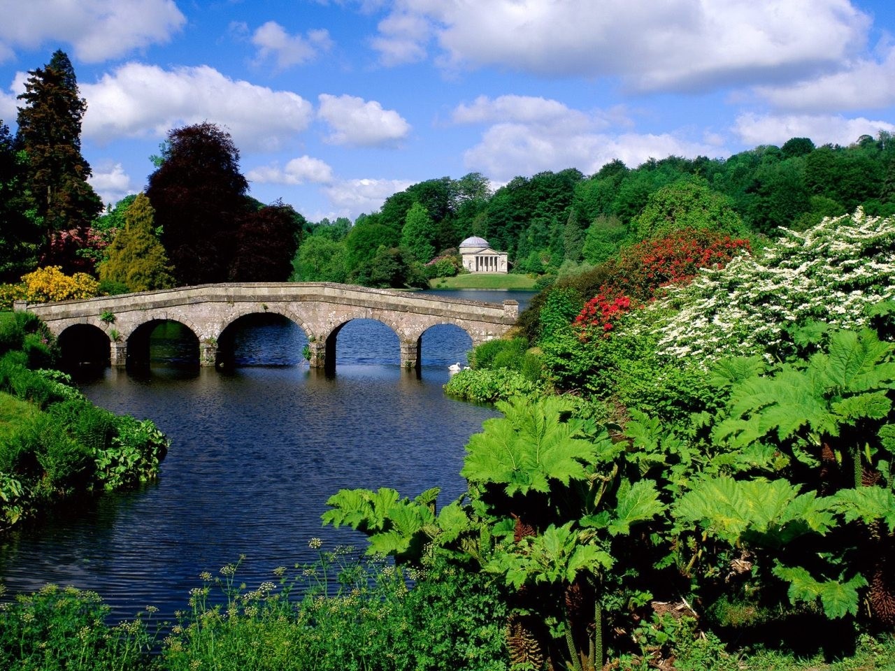 Stone bridge over a lake with a temple in the background HD Wallpaper