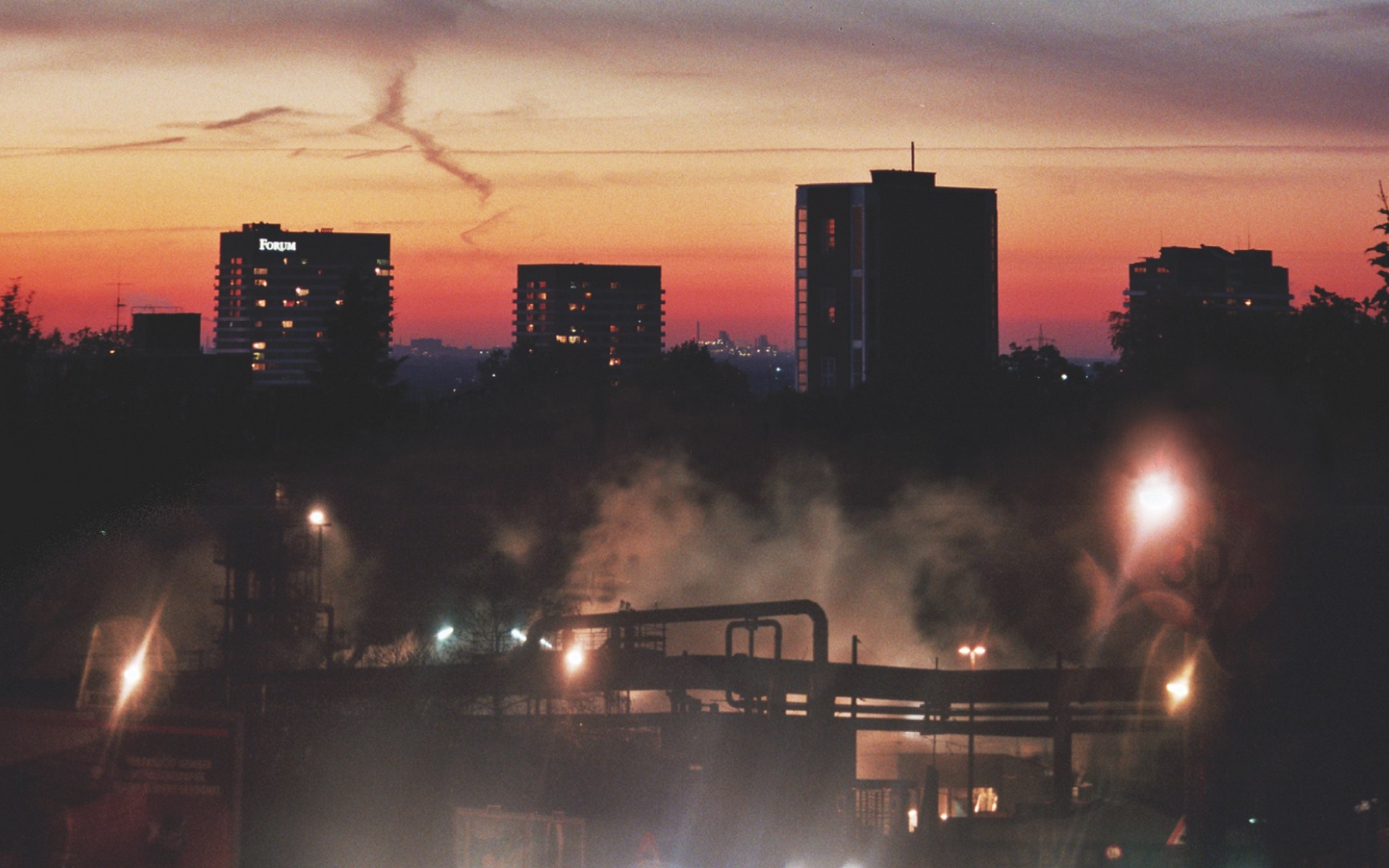 Industrial area with city skyline at sunset HD Wallpaper