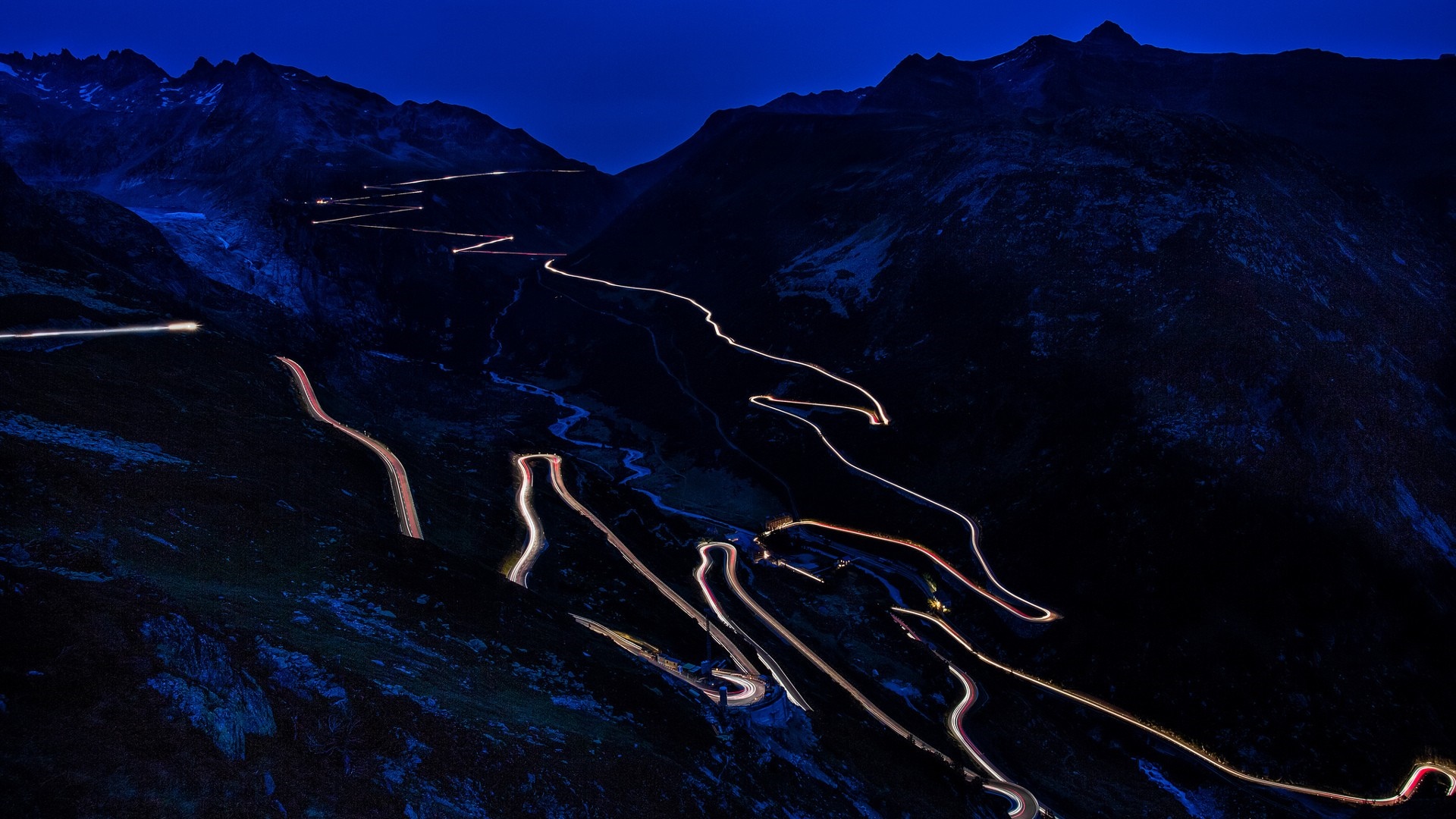 Mountain road with car light trails at night HD Wallpaper