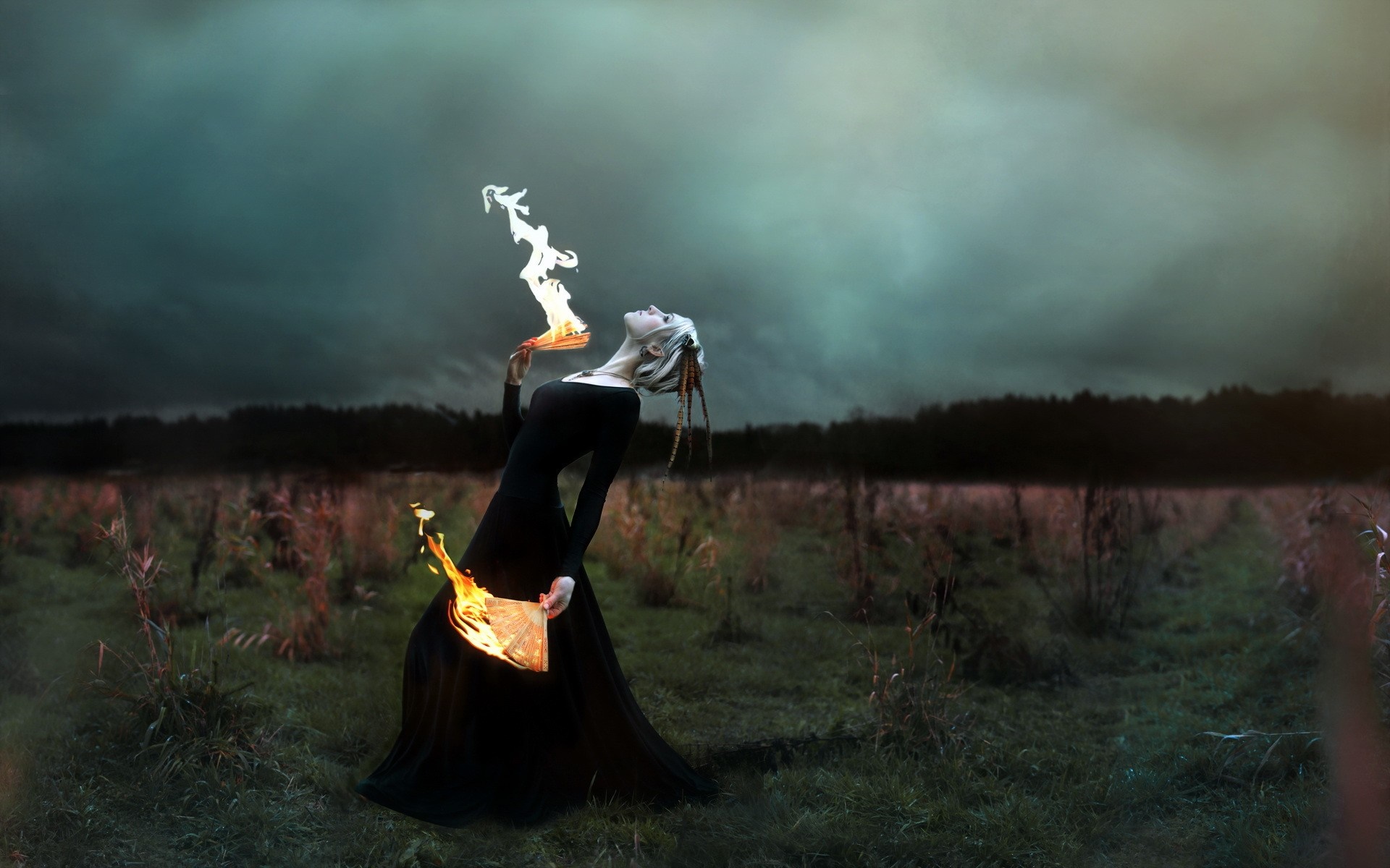 Woman performing fire magic in a field HD Wallpaper