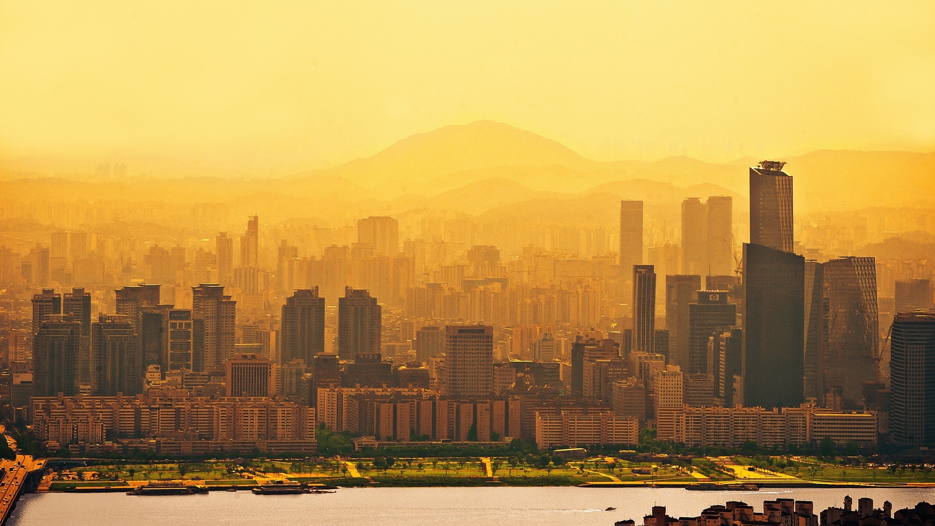 Seoul cityscape at sunset with mountains in the background HD Wallpaper