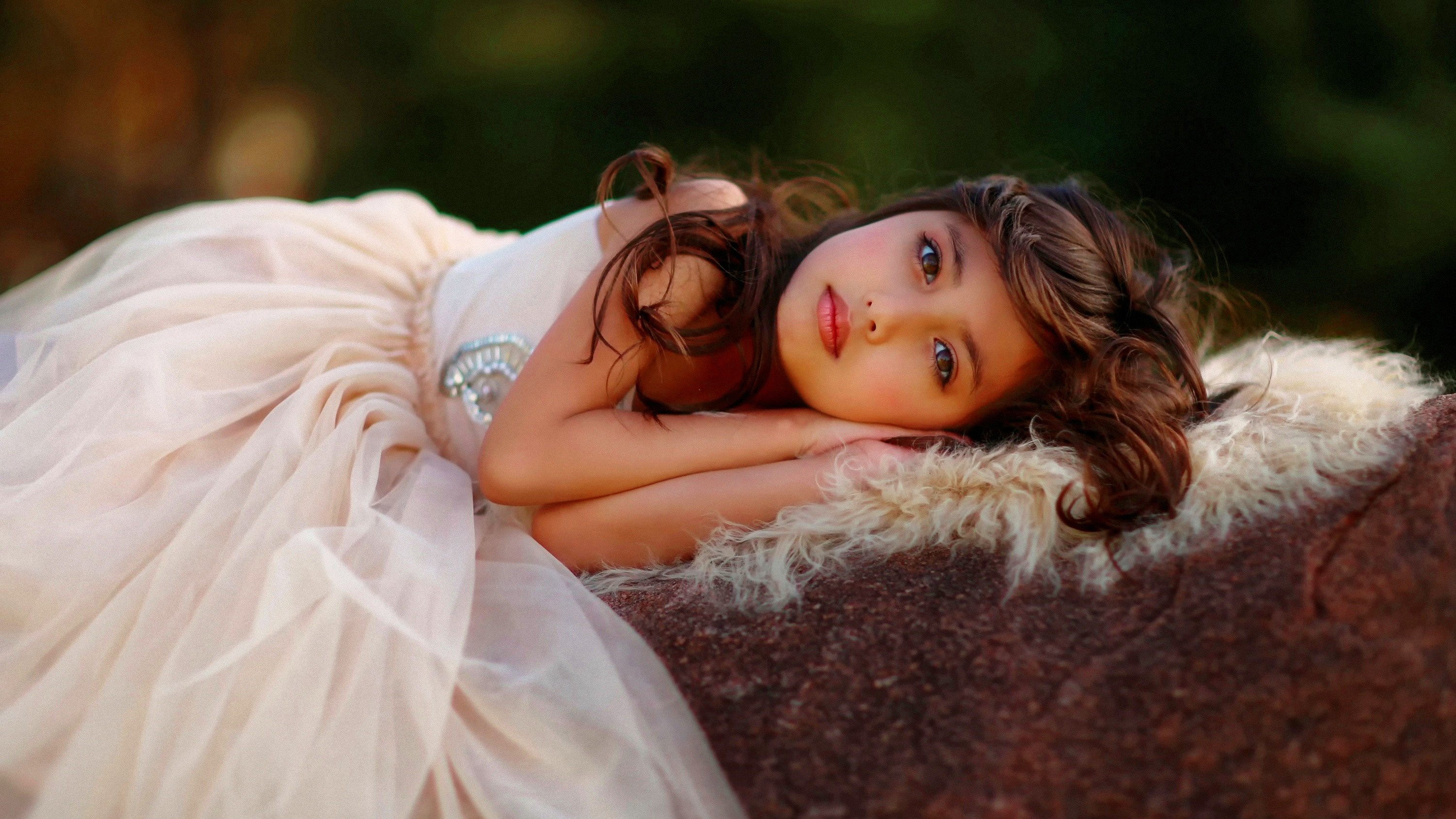 Young girl in a light pink dress lying on a rock HD Wallpaper
