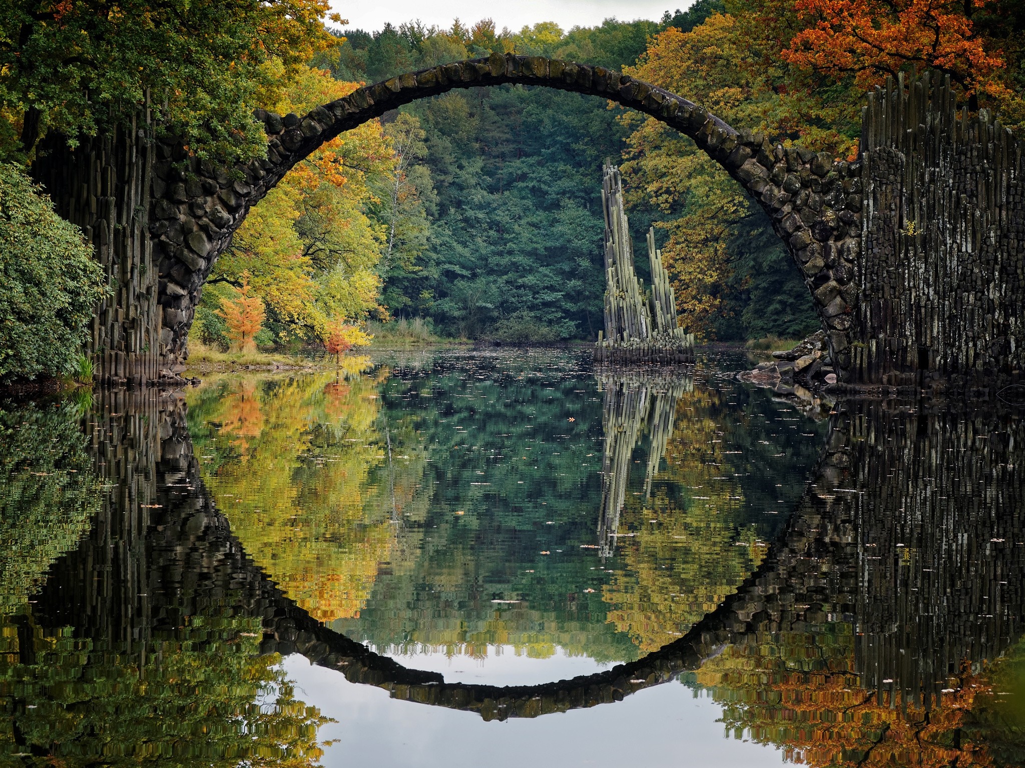Rakotzbrücke bridge reflection in autumn forest lake HD Wallpaper